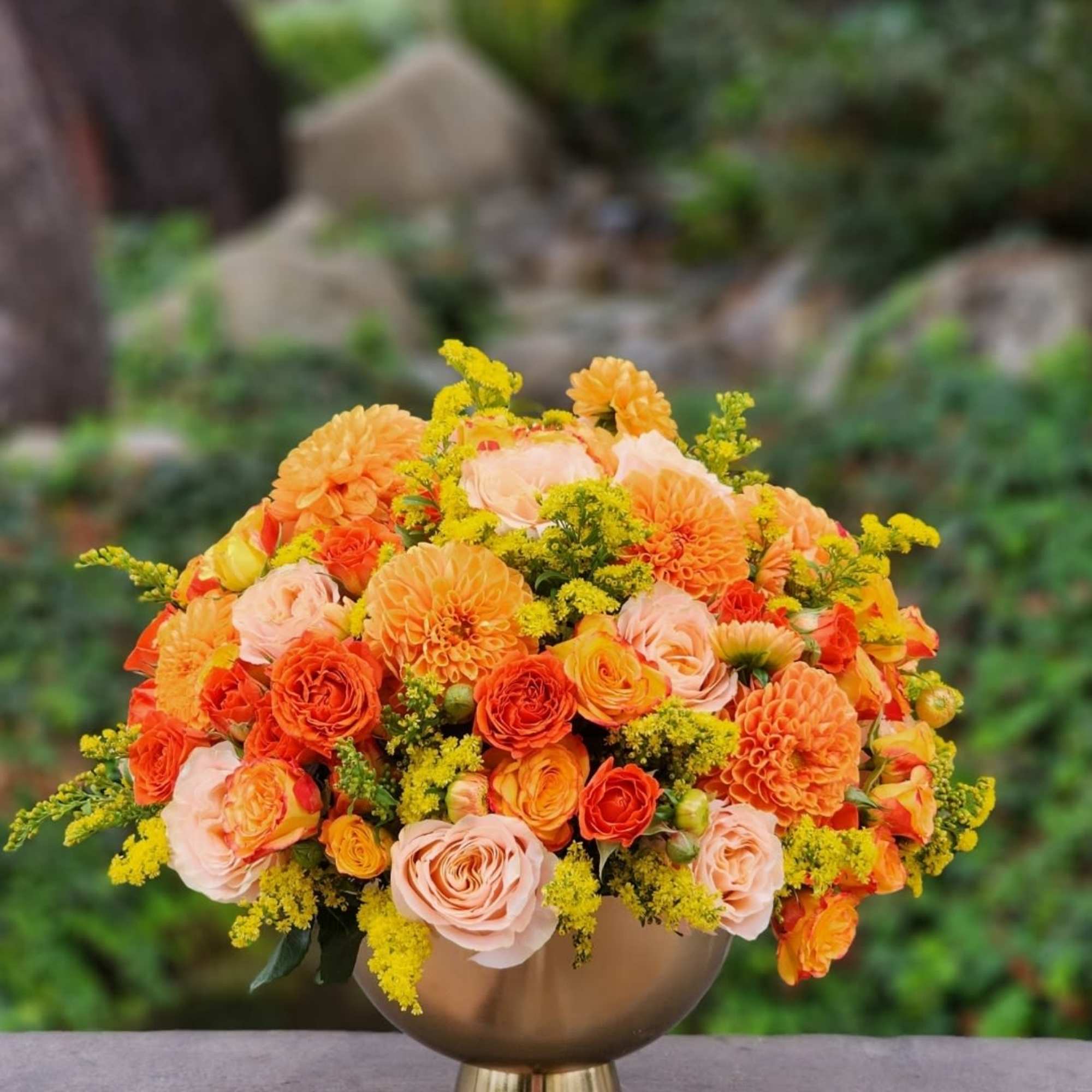 Celebrate autumn with this vibrant arrangement of orange dahlias, roses, and yellow
