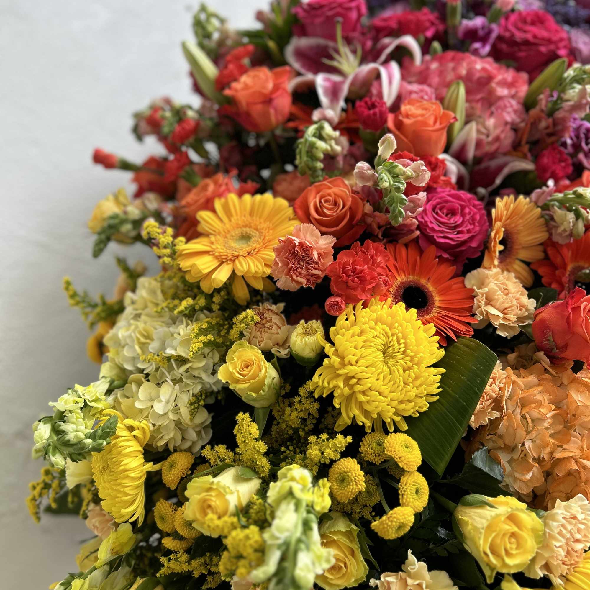 A beautiful multi colored casket blanket.