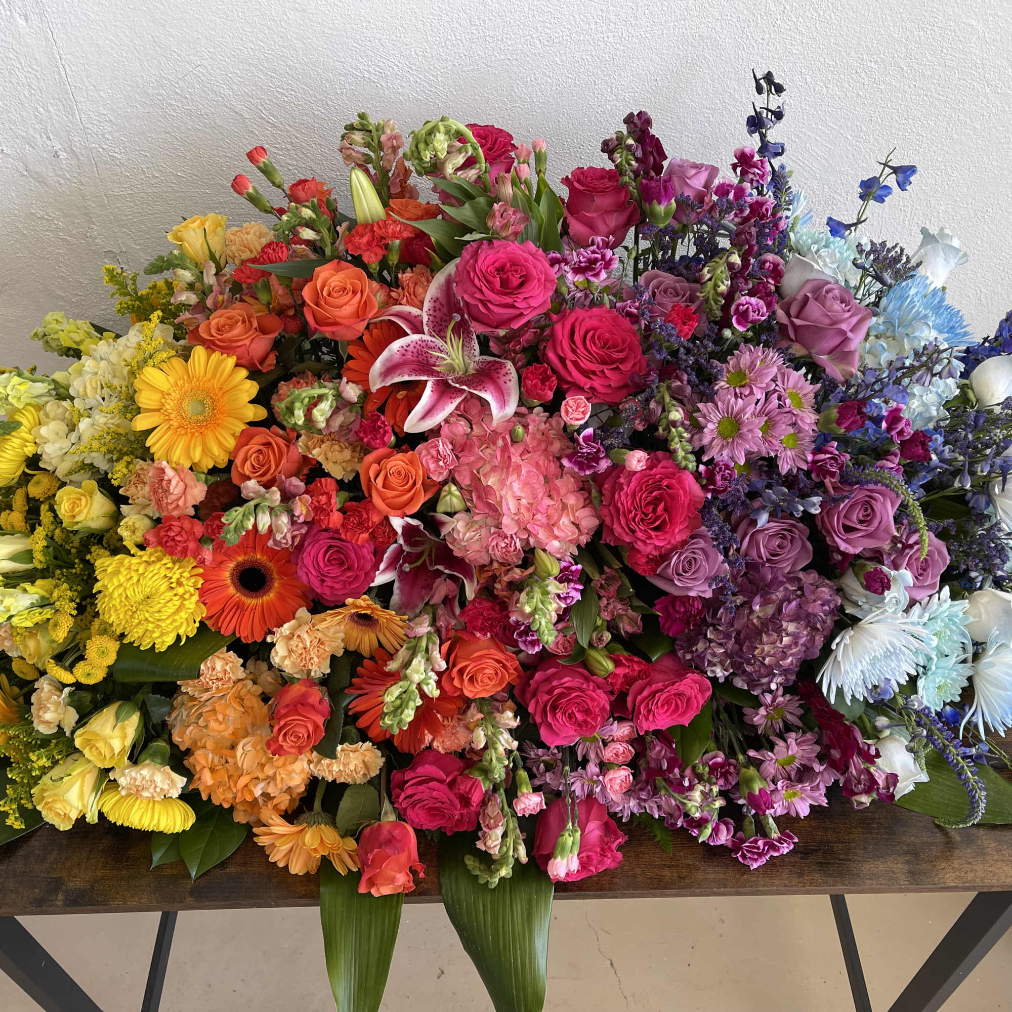A beautiful multi colored casket blanket.