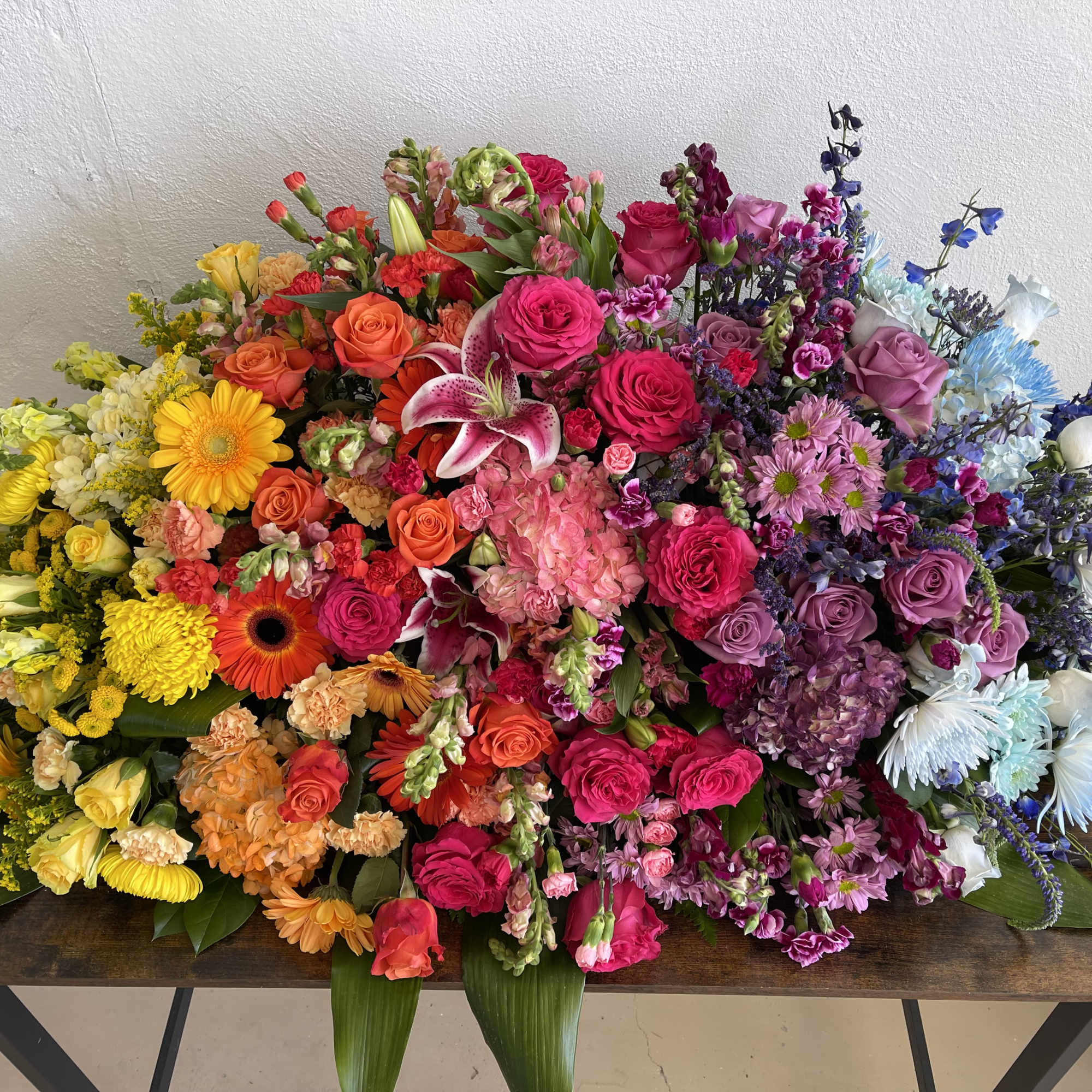 A beautiful multi colored casket blanket.