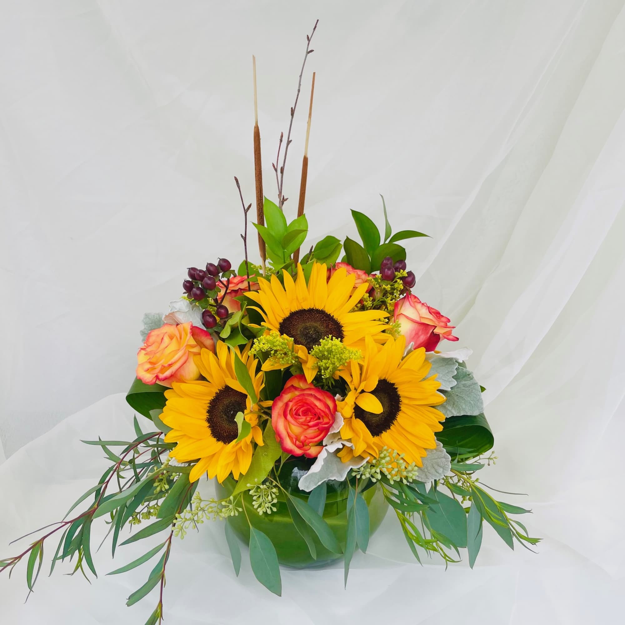 An assortment of roses and sunflowers with touches of fall!