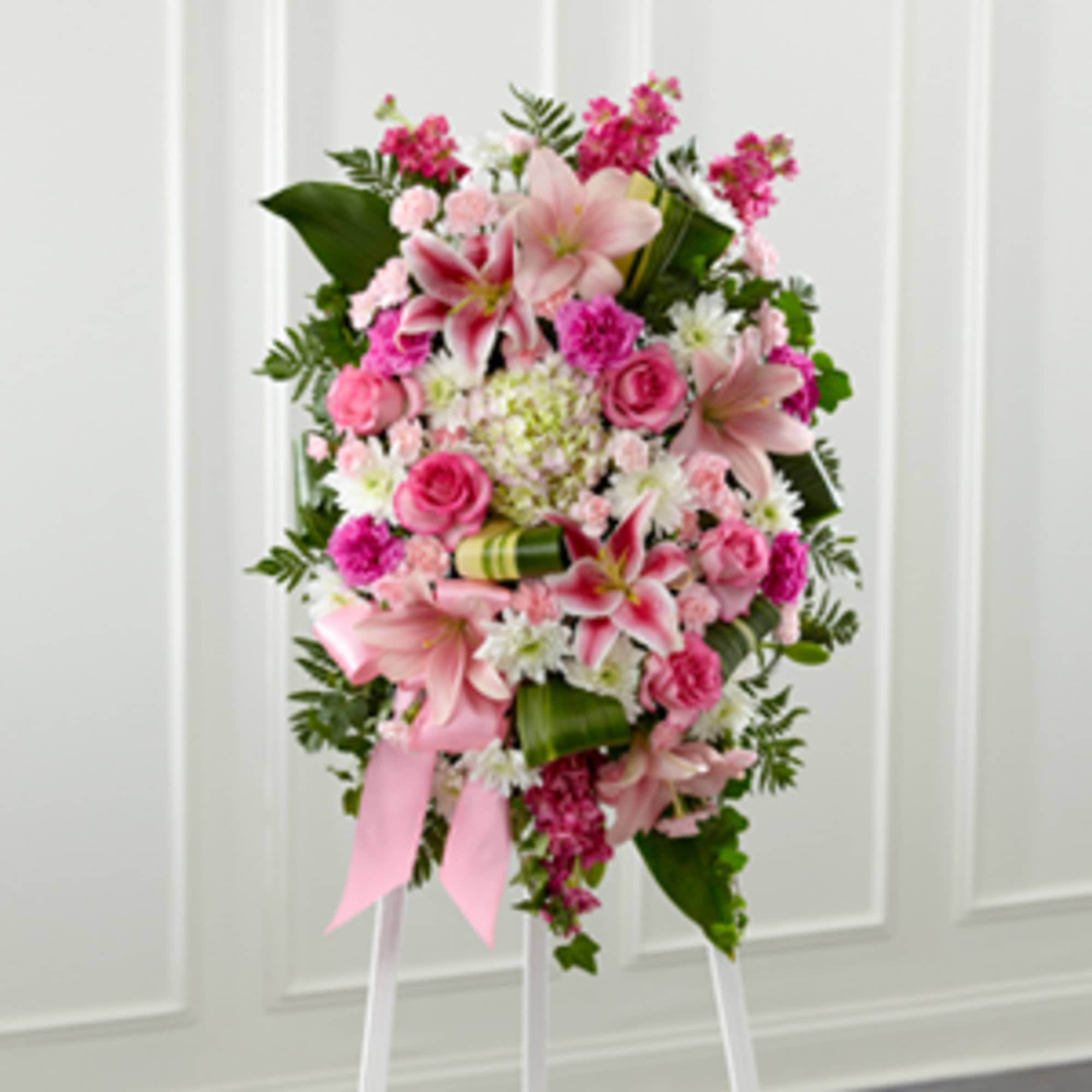 Soft pinks, deeper pinks and lush green foliage are fashioned into an Soft pinks, deeper pinks and lush green foliage are fashioned into an