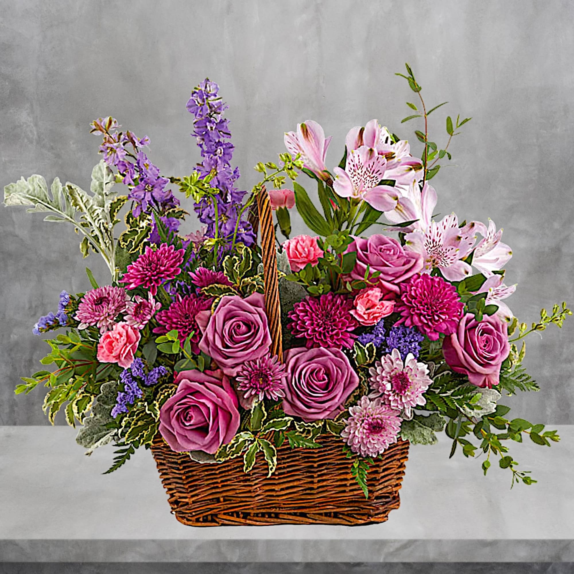 This lush lavender rose arrangement is a basket of beauty to brighten