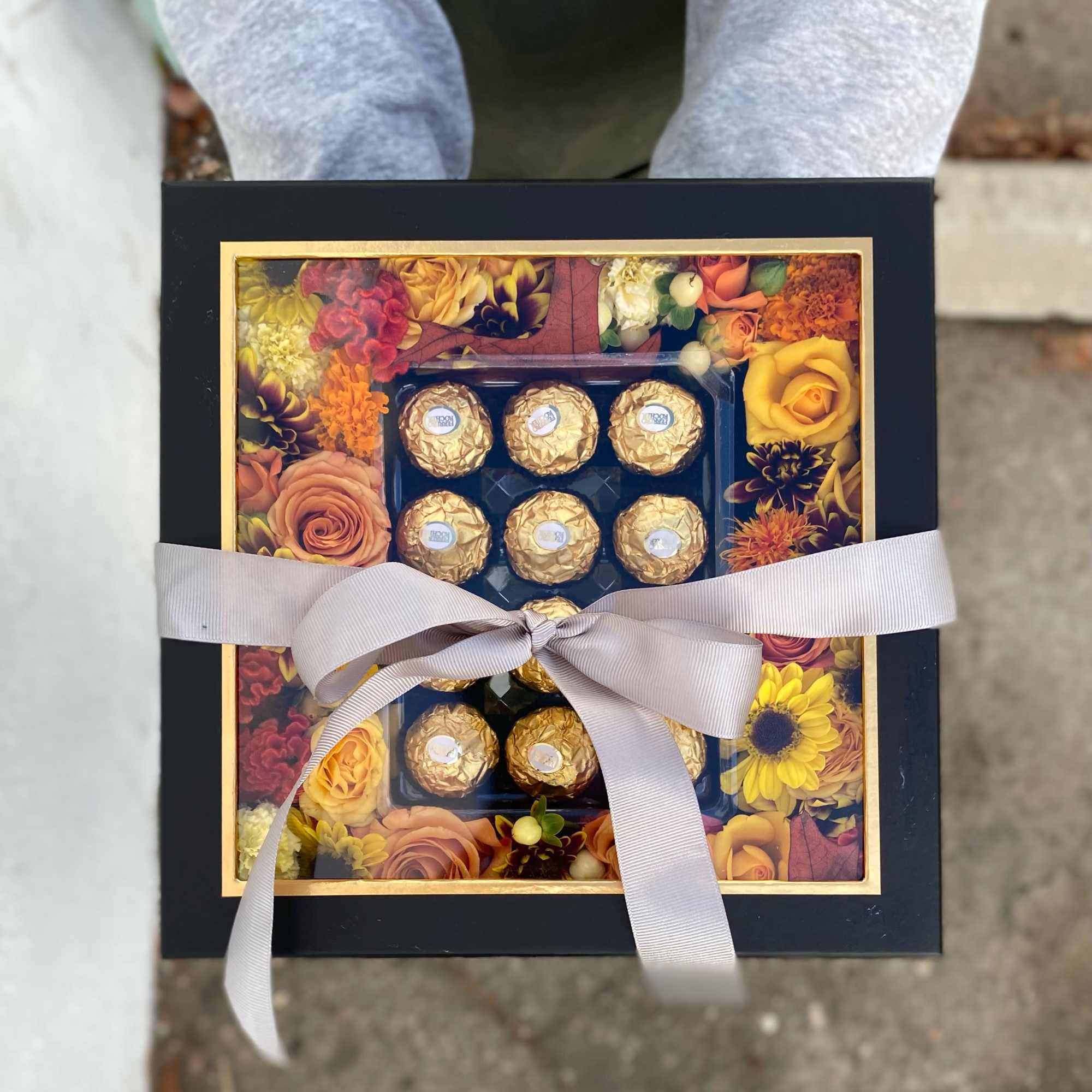 This arrangement includes variety of fall color flowers with ferrero chocolates. 