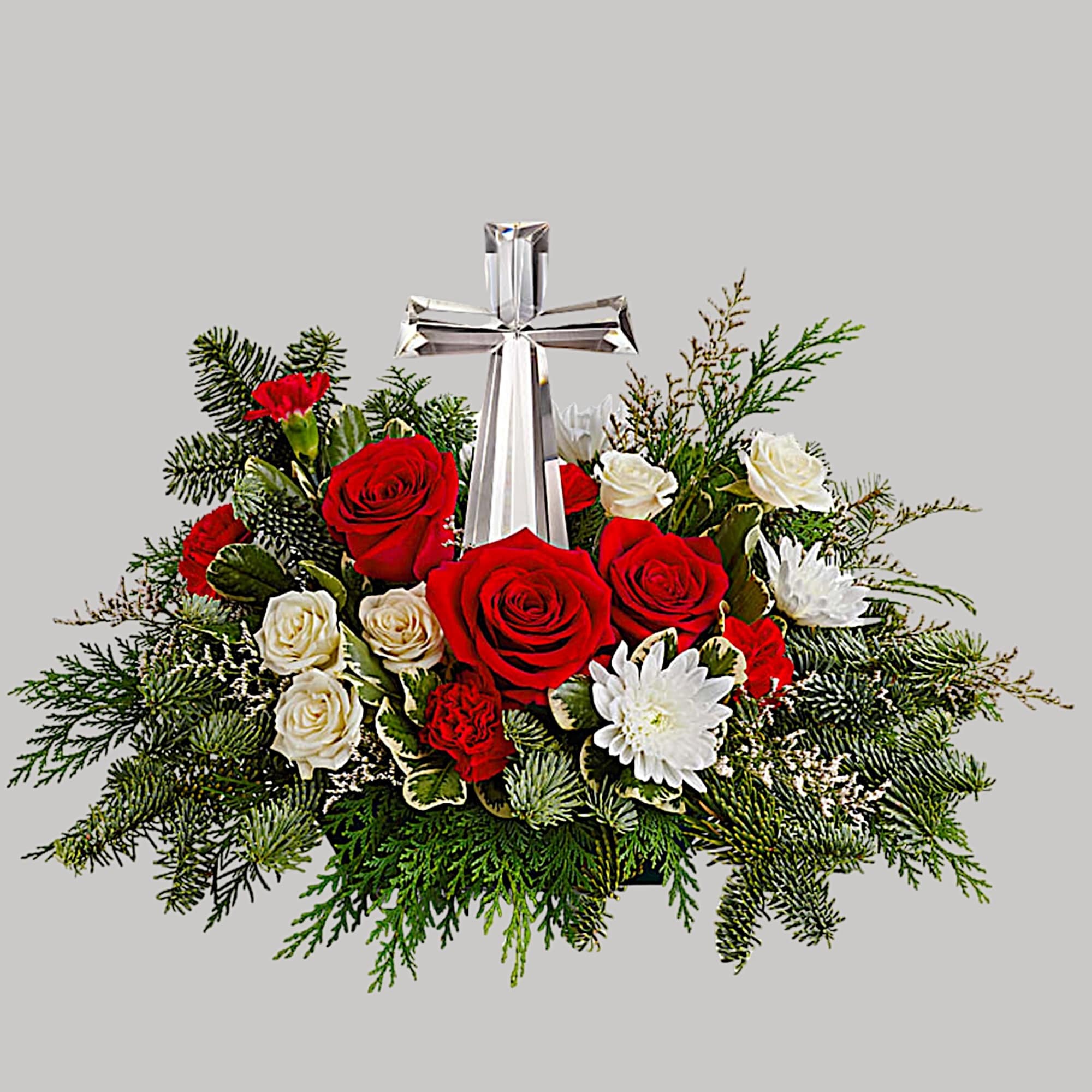 The crystal cross is nestled elegantly among red and white blooms, this