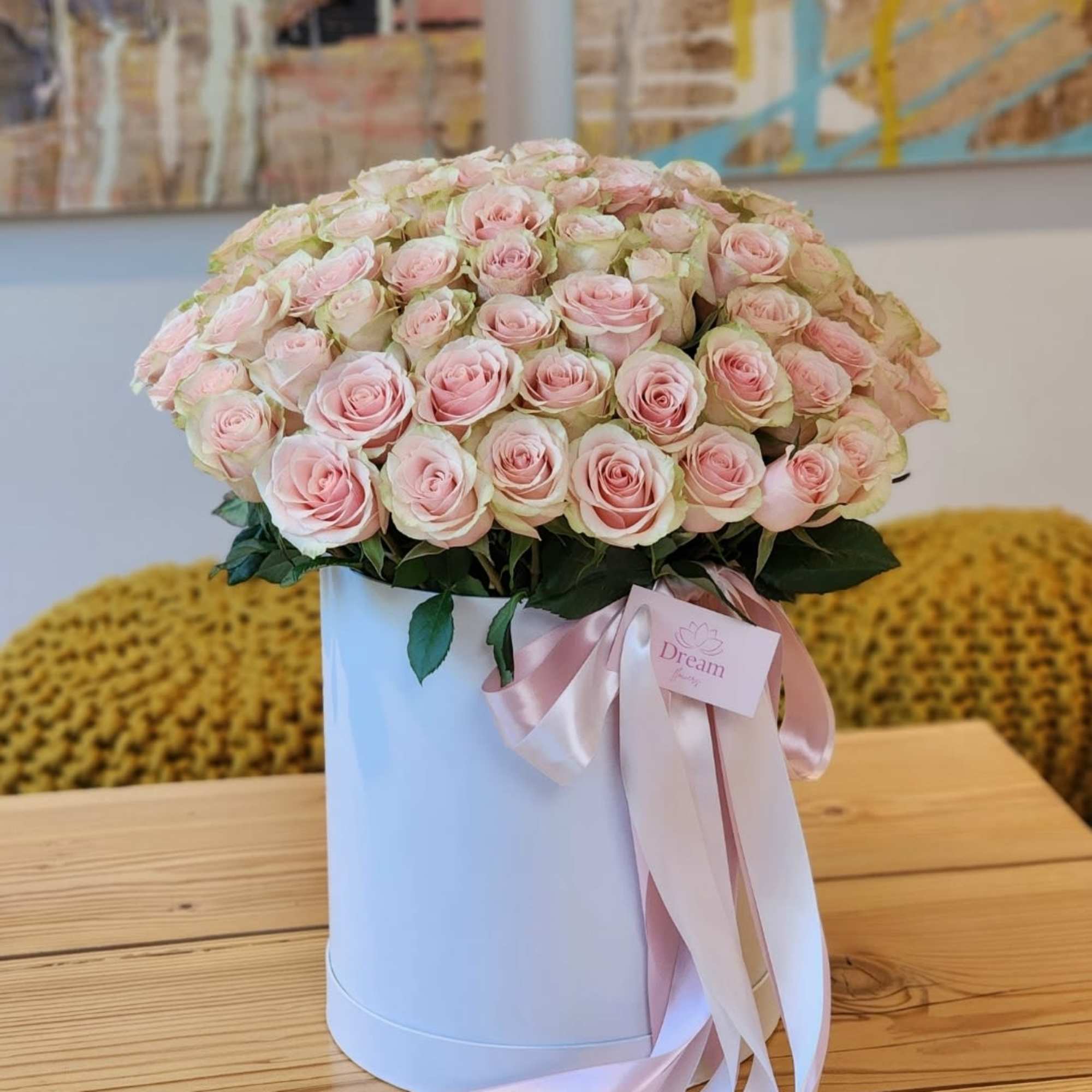 Beauty of pink roses elegantly presented in a chic white hatbox. This