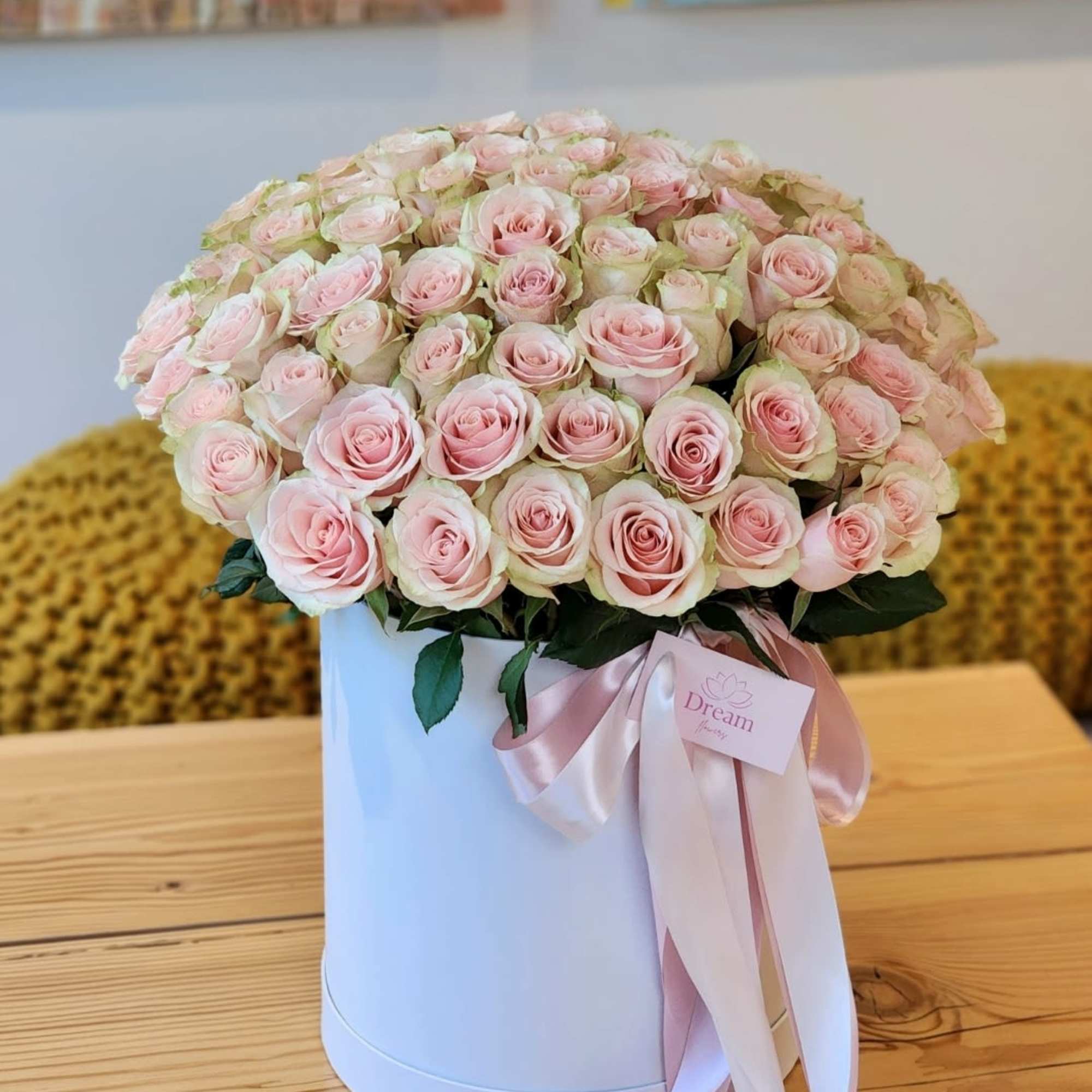 Beauty of pink roses elegantly presented in a chic white hatbox. This