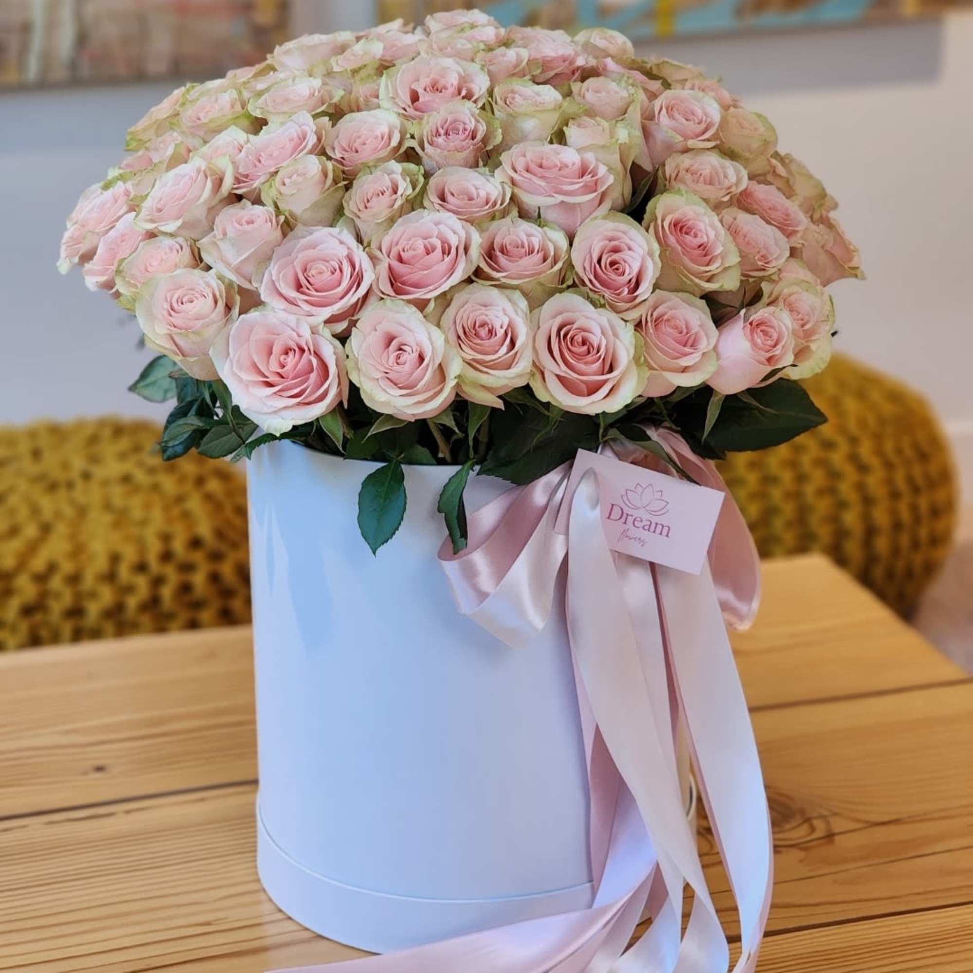Beauty of pink roses elegantly presented in a chic white hatbox. This