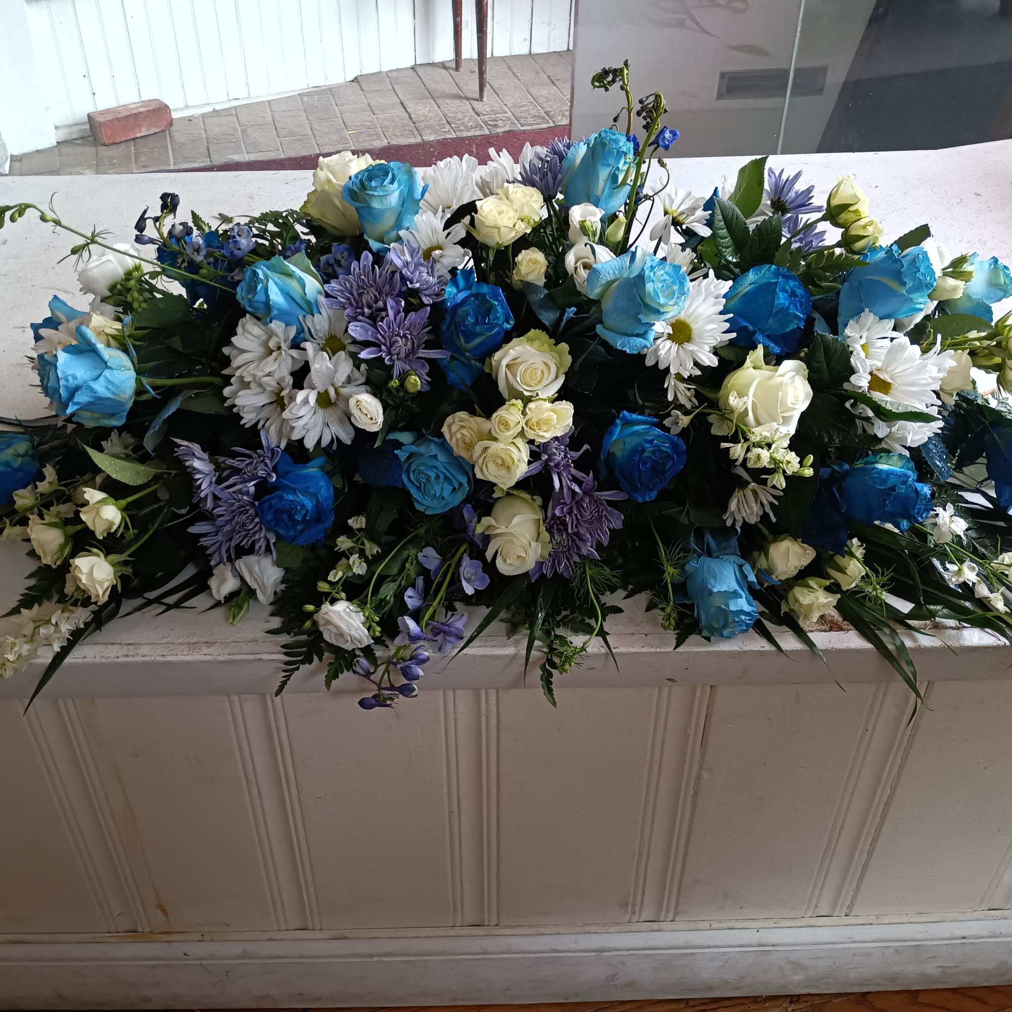 Beautiful deep and light blue and white roses, white daises, carnations, blue