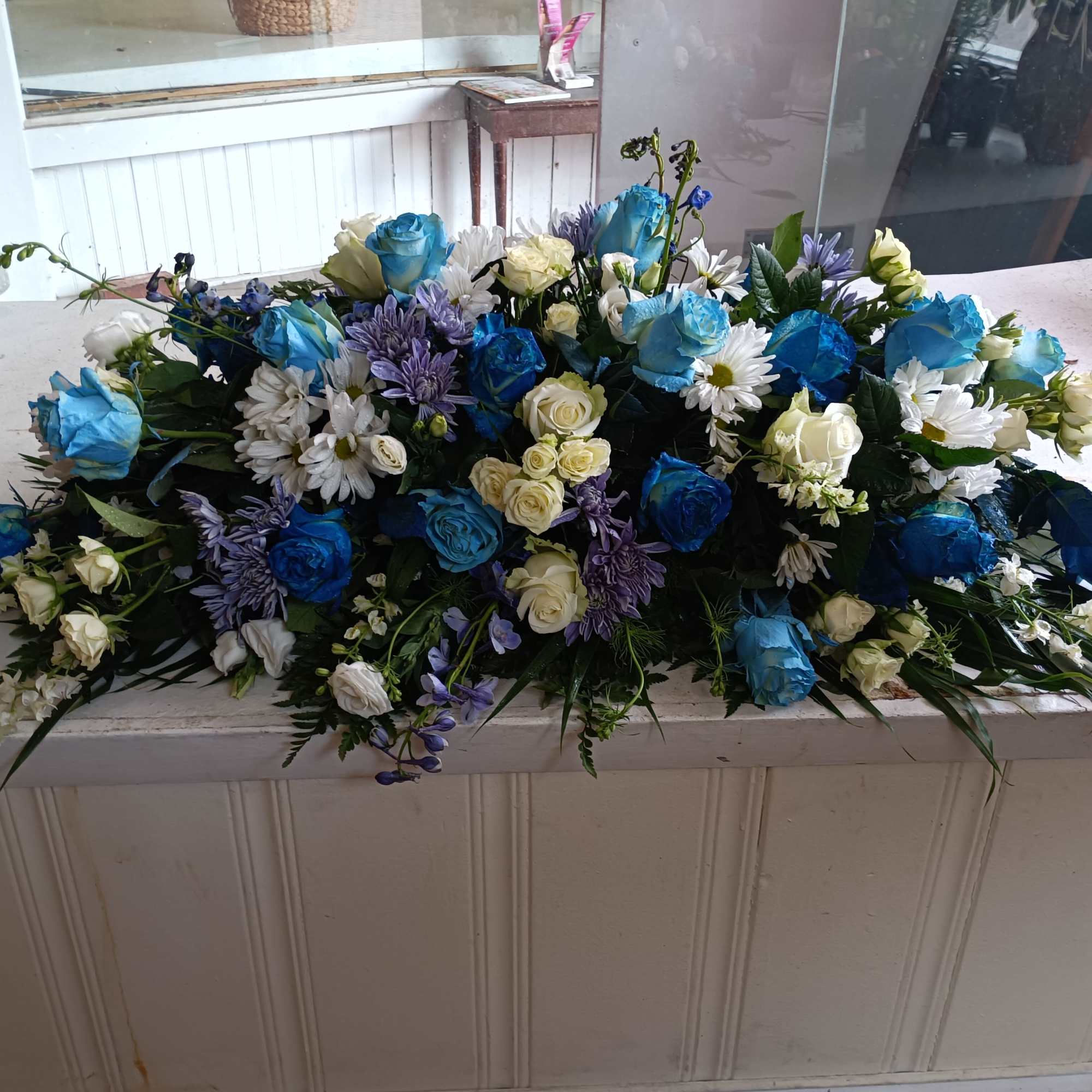 Beautiful deep and light blue and white roses, white daises, carnations, blue