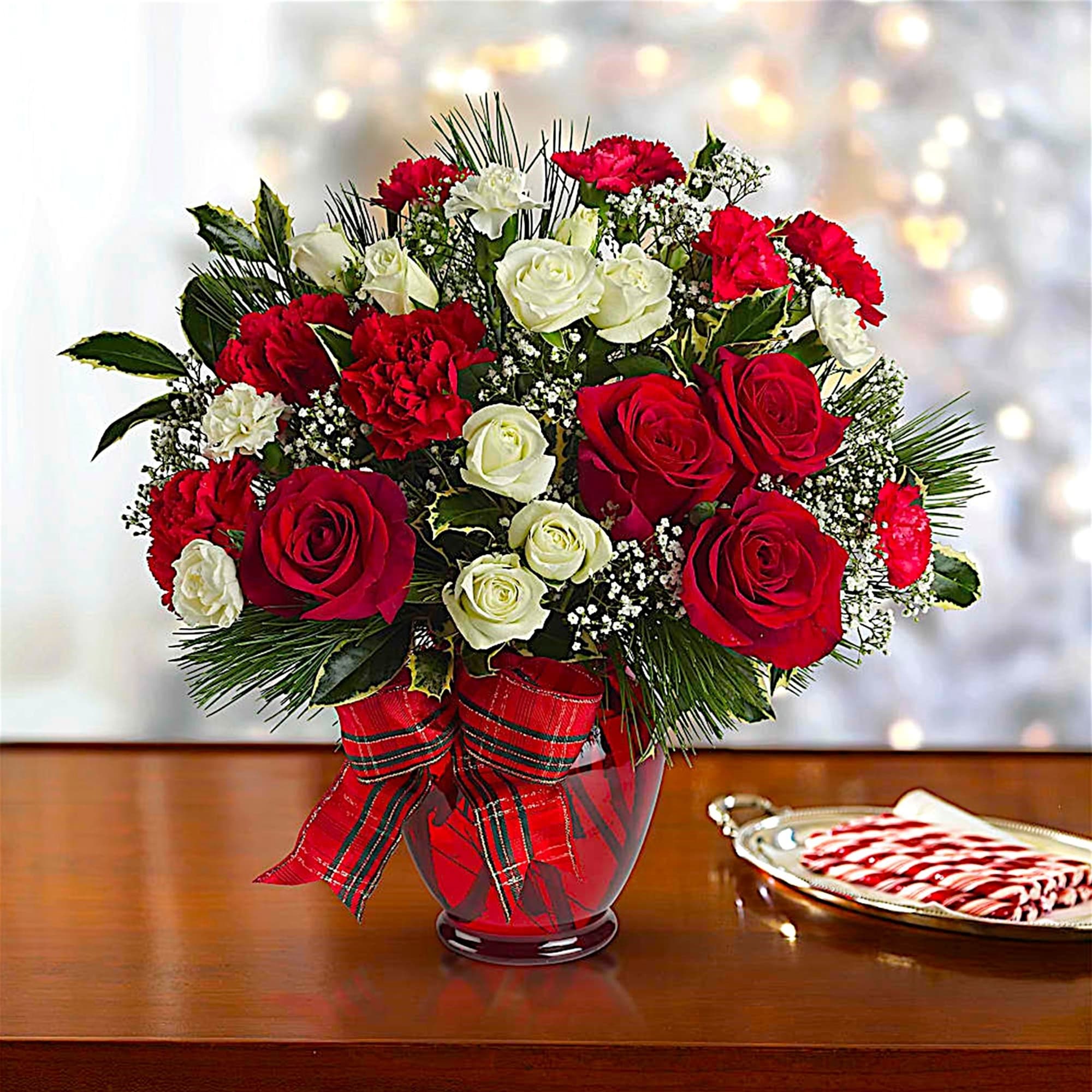 All dressed up in classic Christmas colors, this holiday floral arrangement is