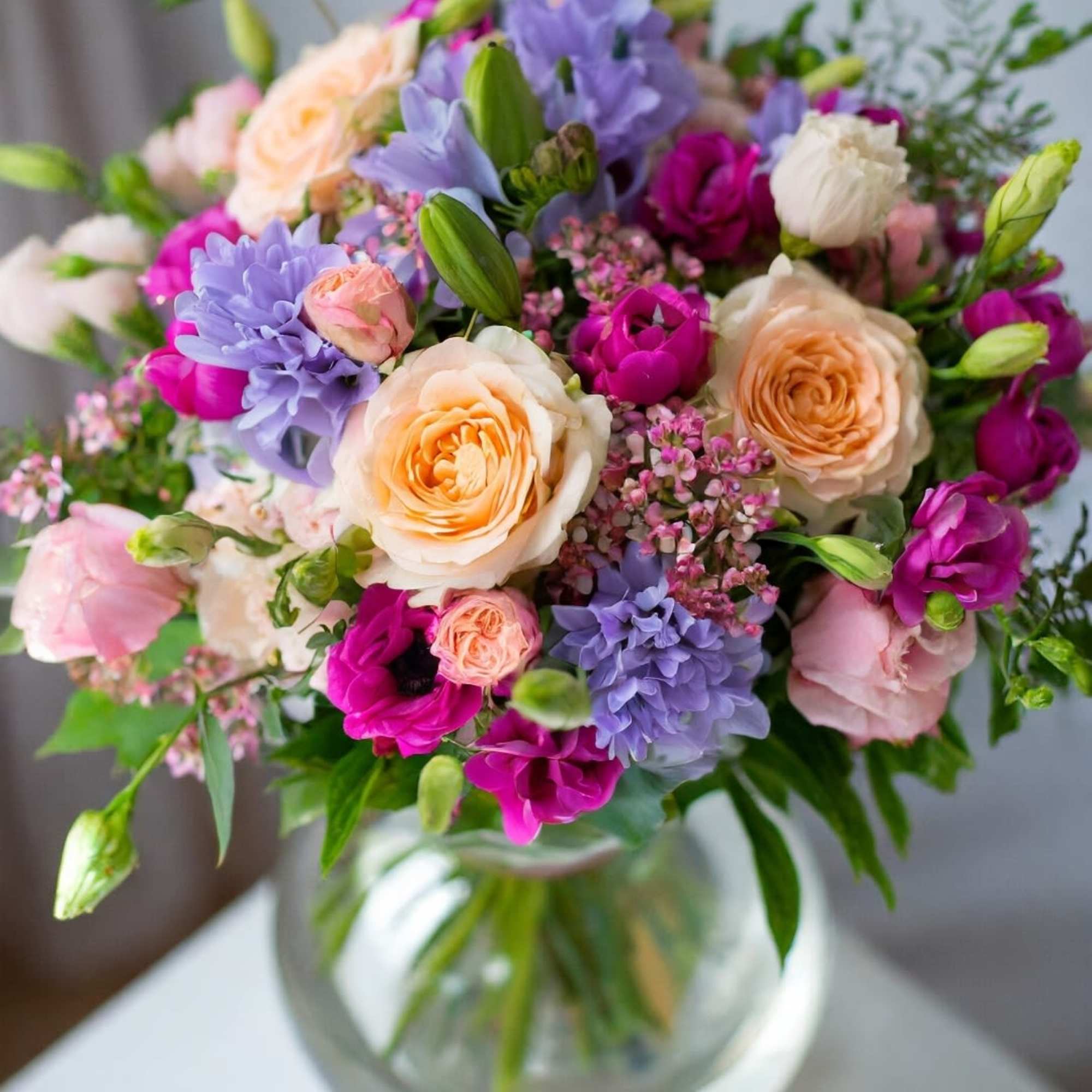 Our garden-style vases feature peach roses and a colorful mix of stunning