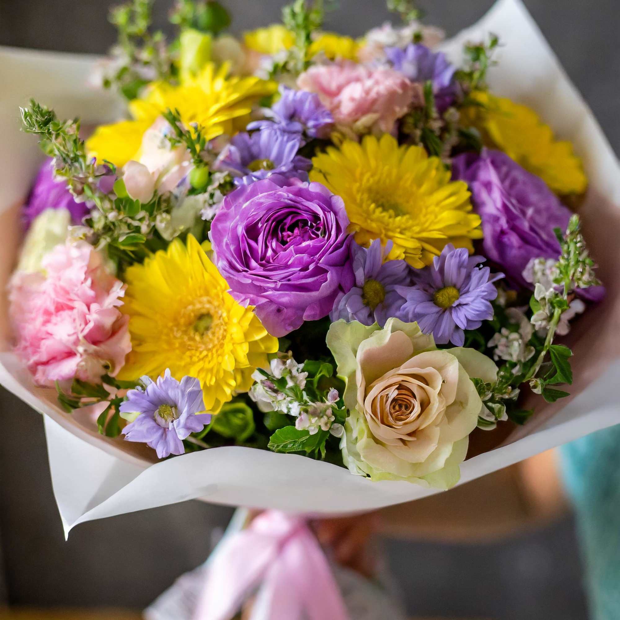 Our stunning bouquet featuring of sunny yellow gerberas, purple roses, and an