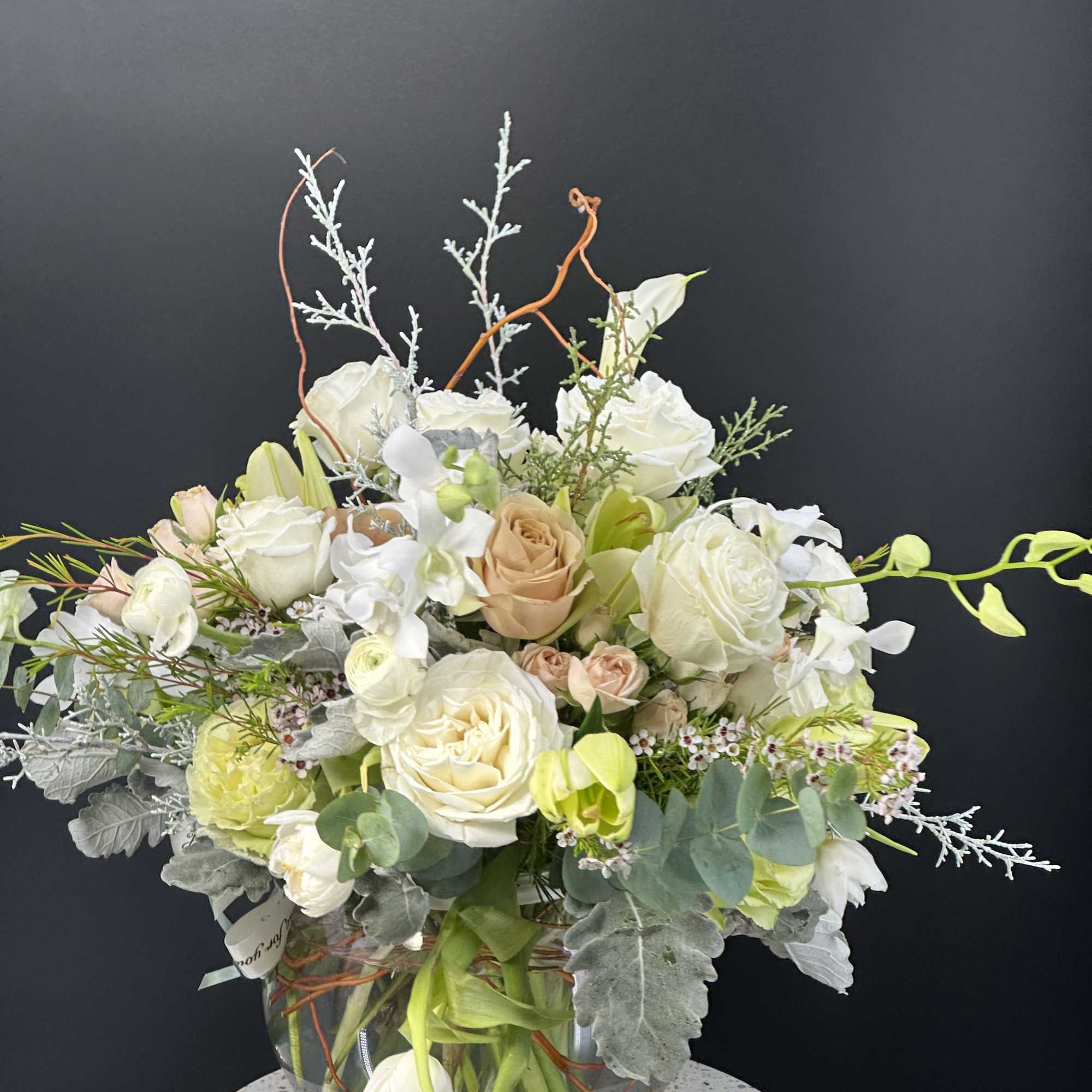 New beginnings deserve flowers! This all white arrangement includes roses, lisianthus and