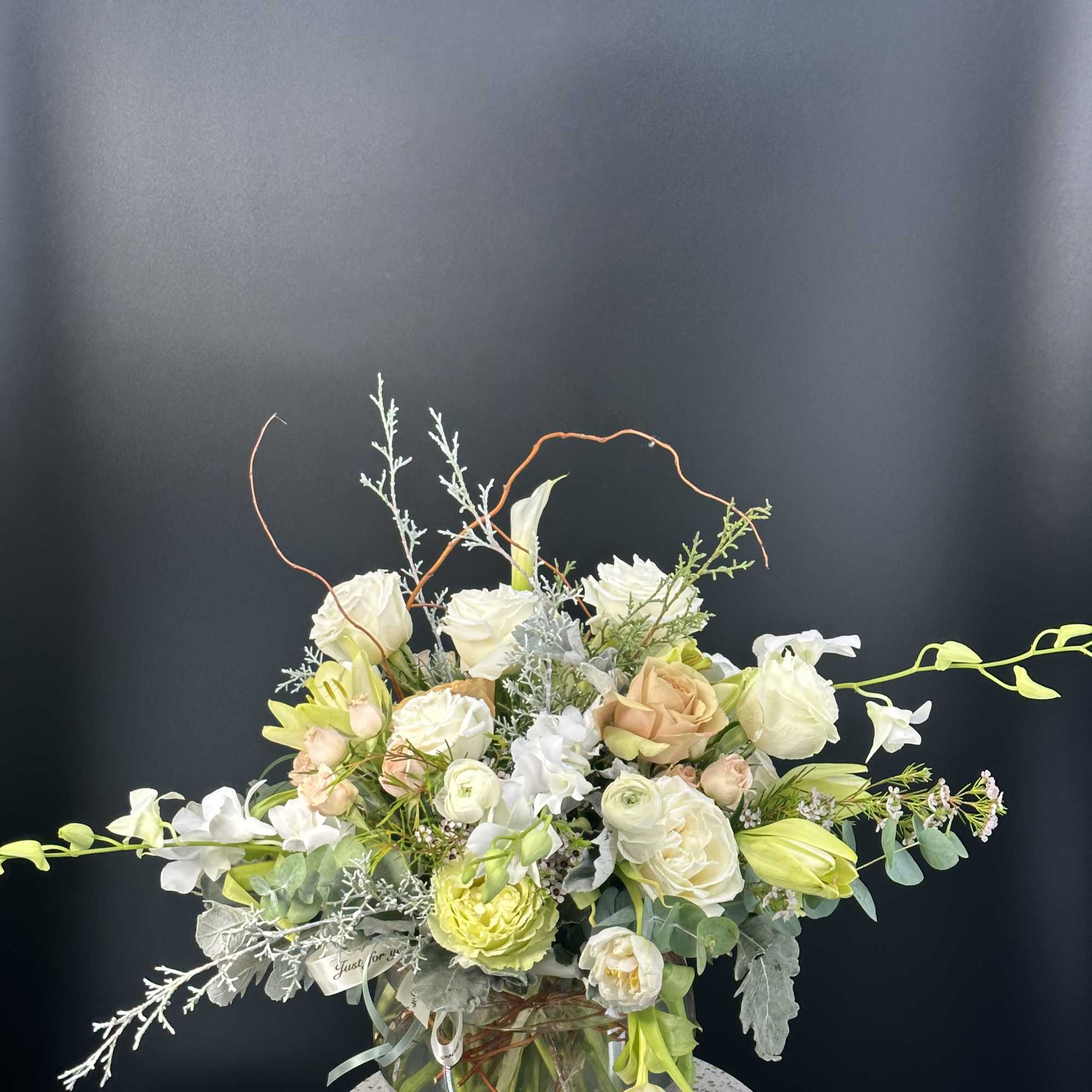 New beginnings deserve flowers! This all white arrangement includes roses, lisianthus and