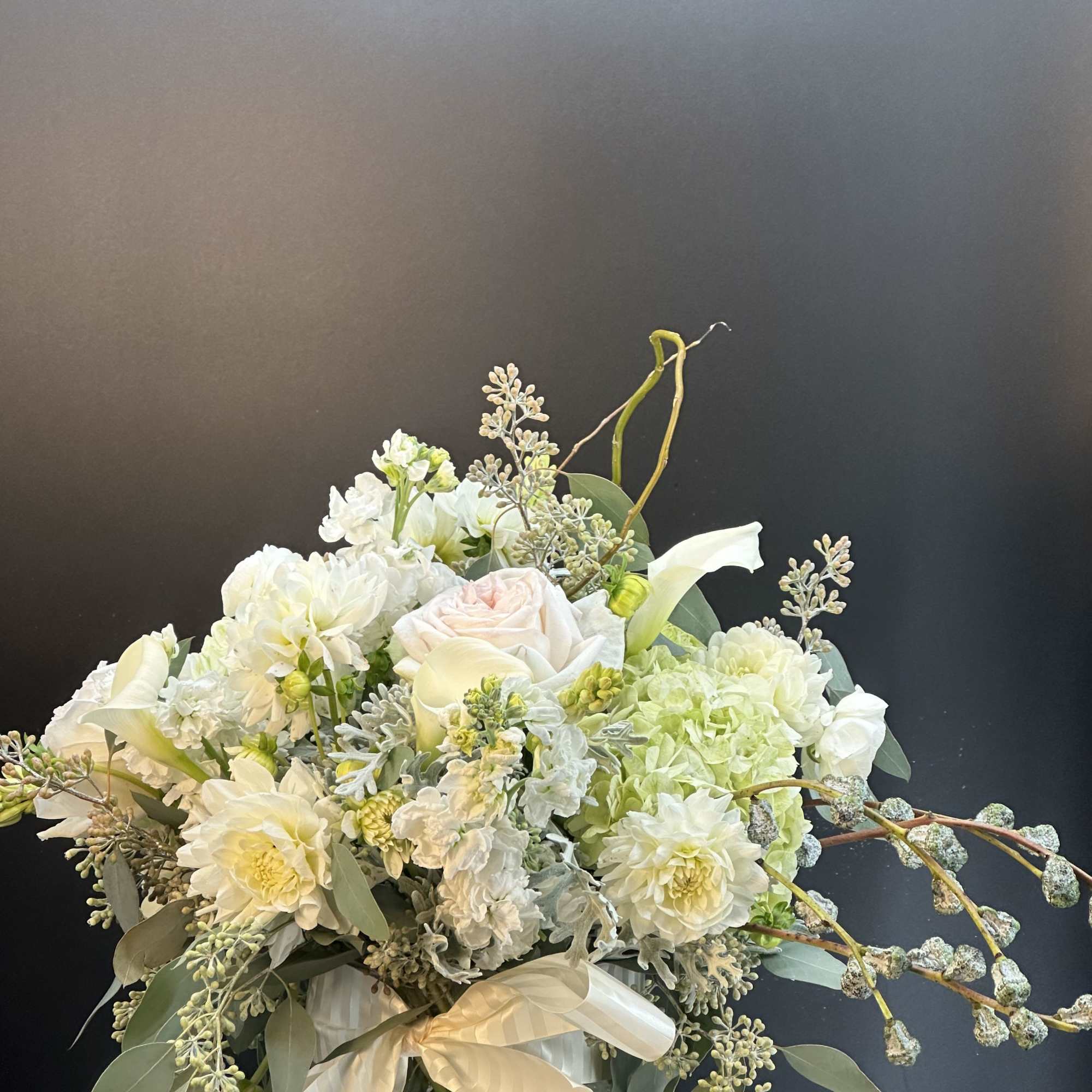 New beginnings deserve flowers! This all white arrangement includes roses, lisianthus and
