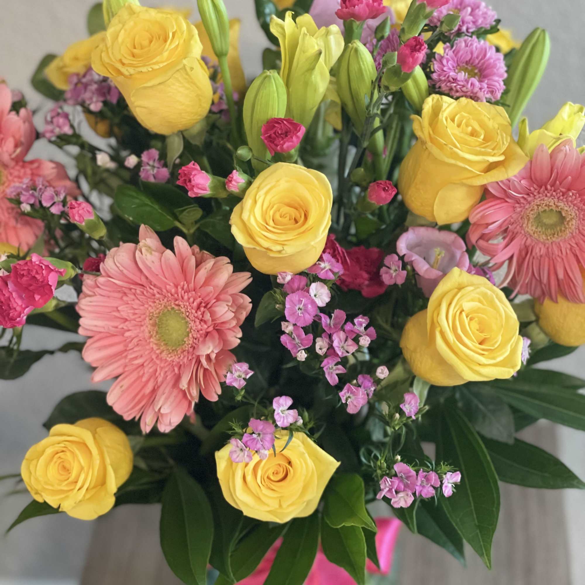 Splendid floral arrangement of yellow roses, pink gerbera daisies, pink carnations, yellow