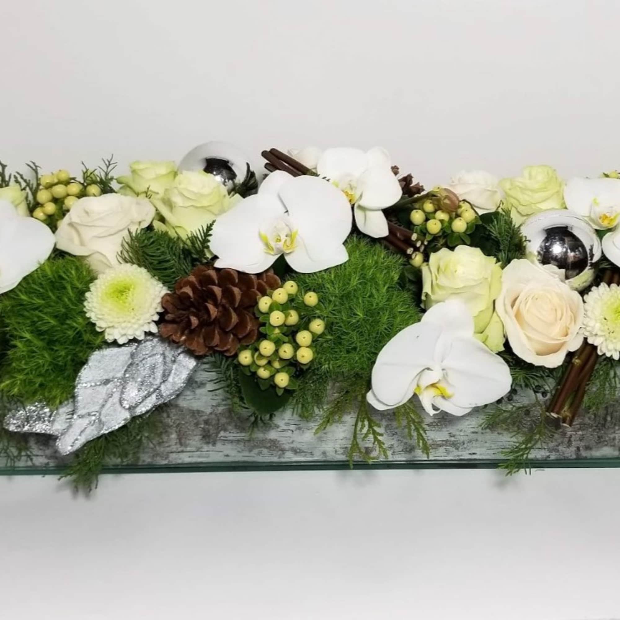 In a vase, an arrangement made of 12 roses, orchids, Christmas silver