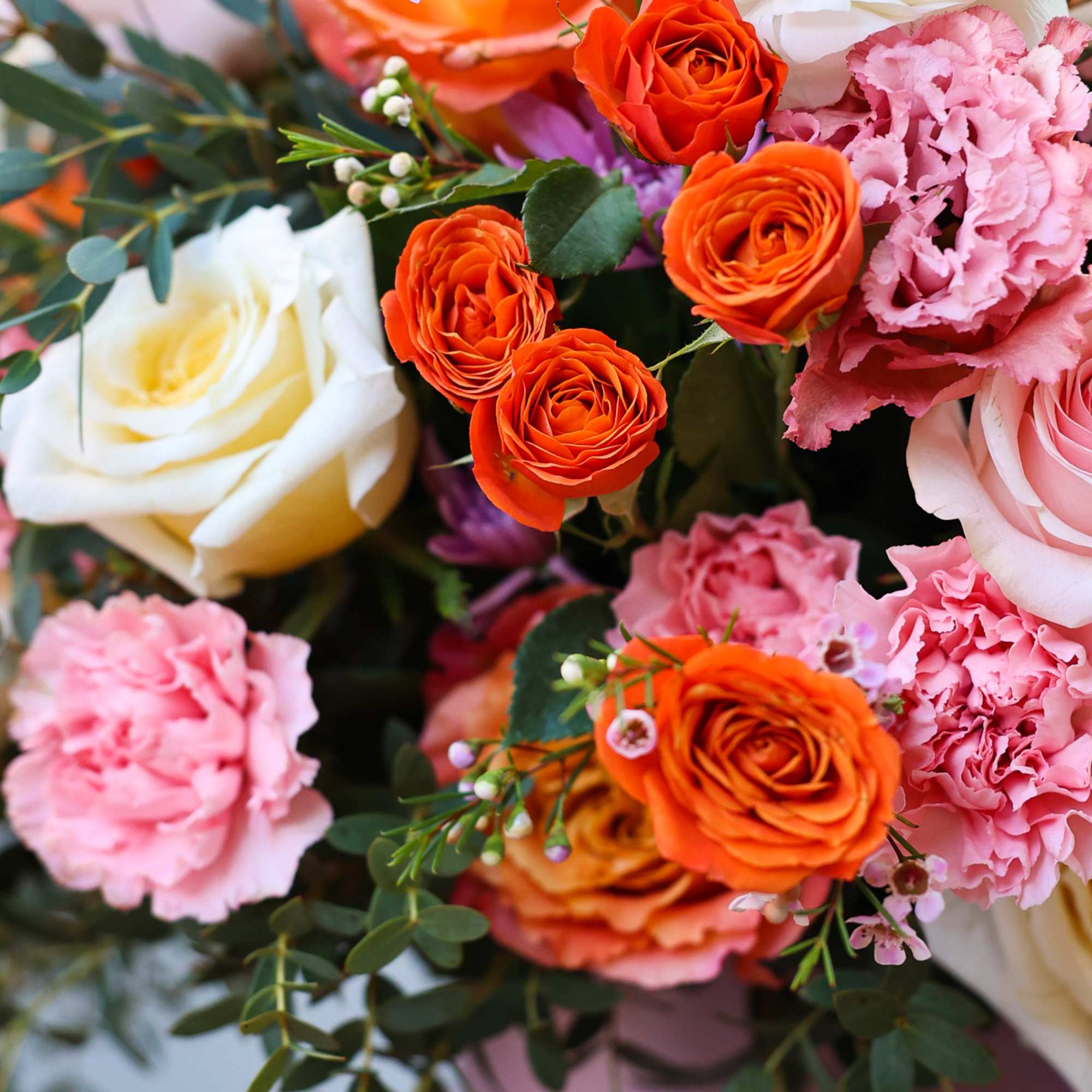 A mix of colorful flowers mixed in a cylindric box