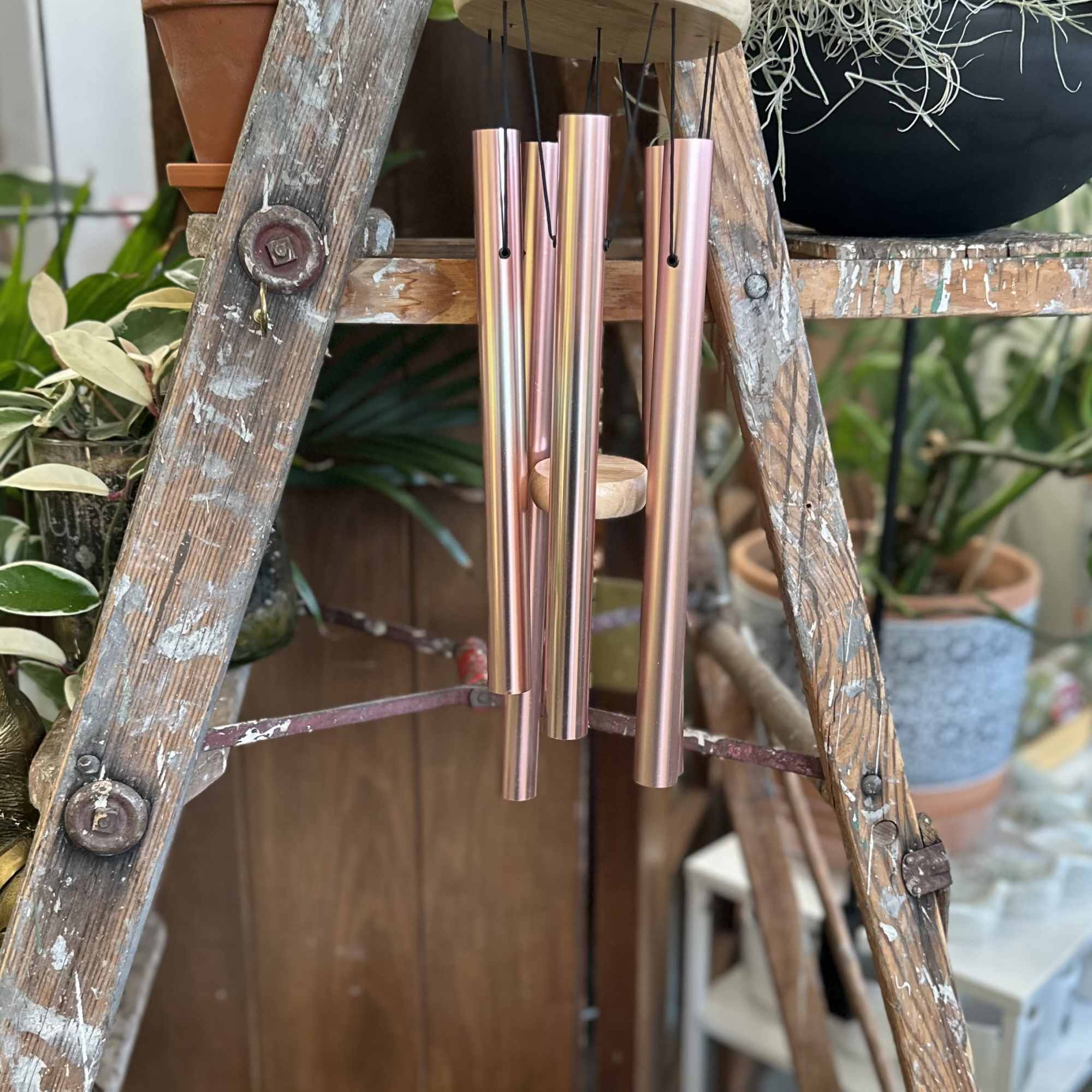 Rose gold chimes with a wooden clapper bearing the sentiment "The Memory Rose gold chimes with a wooden clapper bearing the sentiment "The Memory