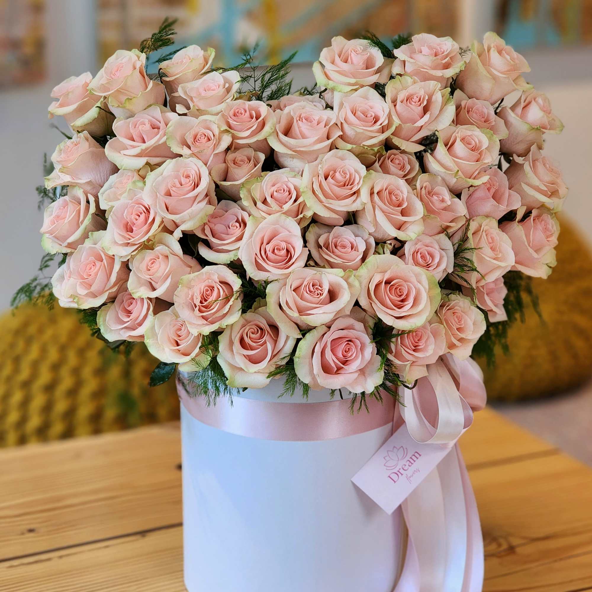 Beauty of pink roses elegantly presented in a chic white hatbox. This