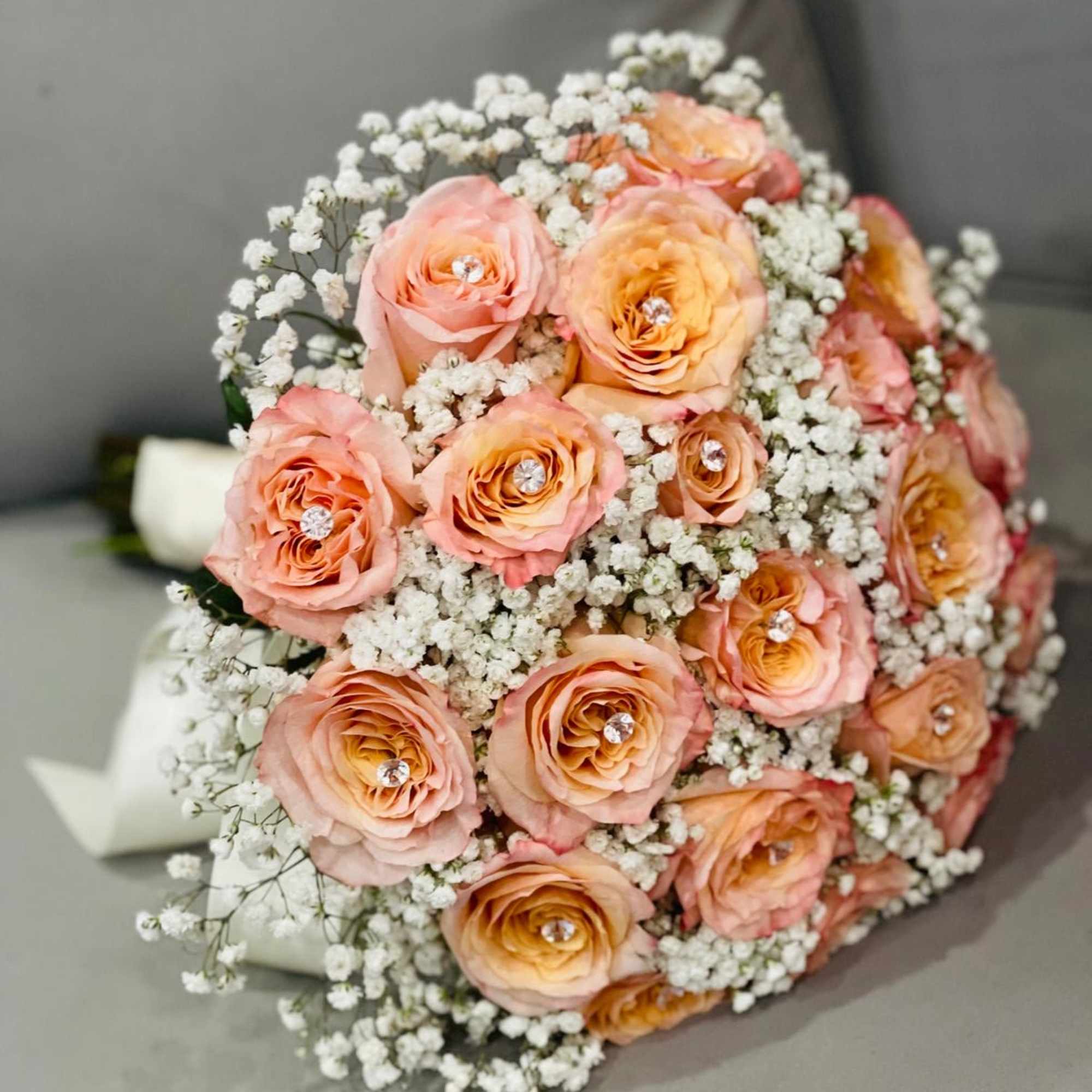 Rose Whispers* is a delicate bridal bouquet crafted with timeless elegance. It