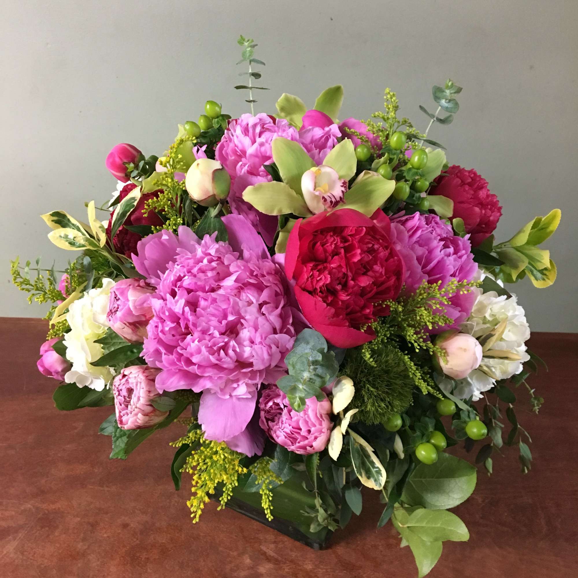 Variety of peonies, green cymbidium and mix greens all arrange in a