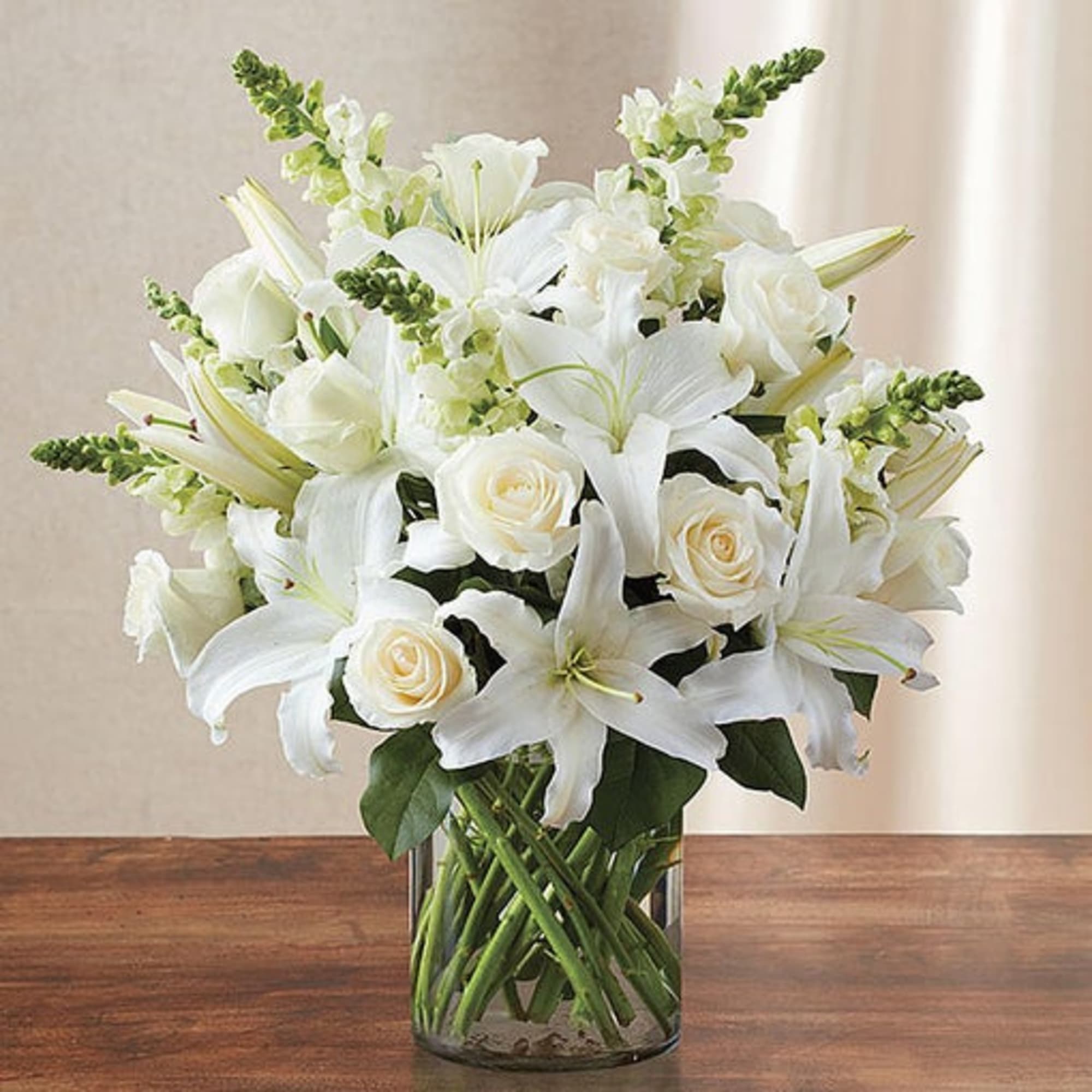 Glorious roses lead the way in this luxurious winter white arrangement. Paired