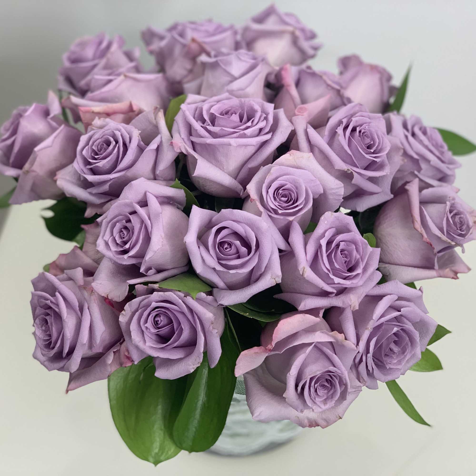 These lavender roses are stunning arranged in a cylinder vase for your