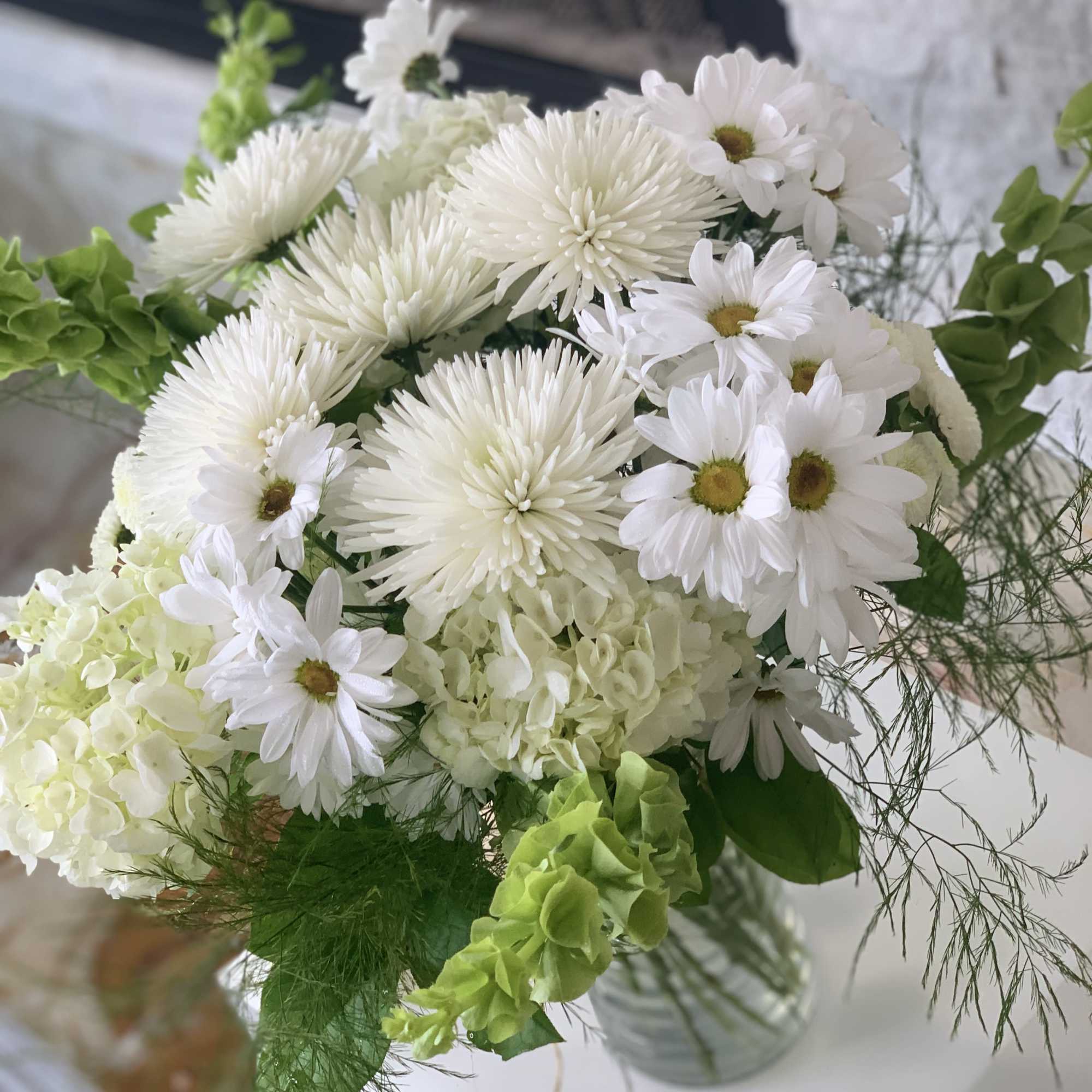 This arrangement is full of variety of daisies and asters with hydrangeas