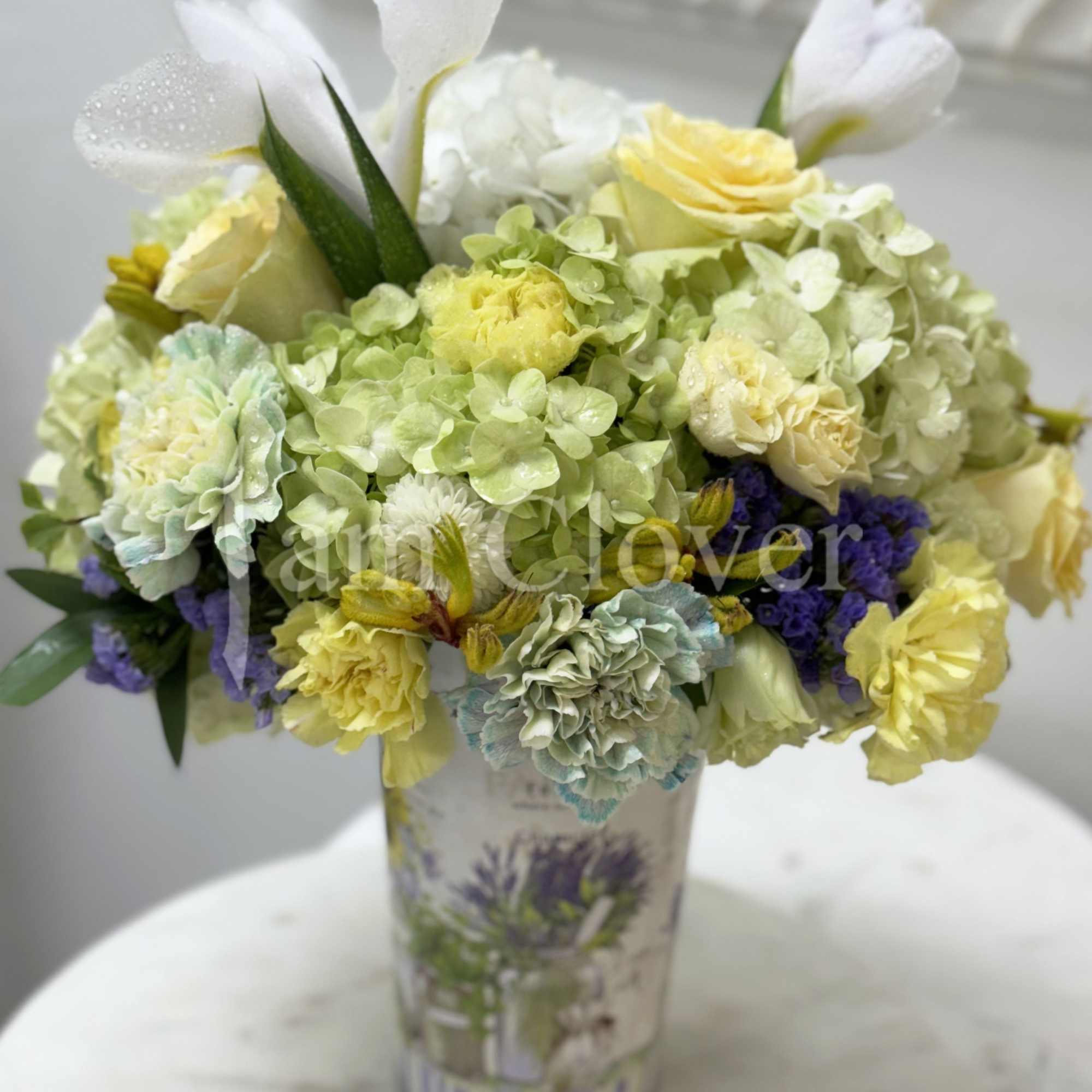This romantic arrangement has a light European fleur containing blush yellow and
