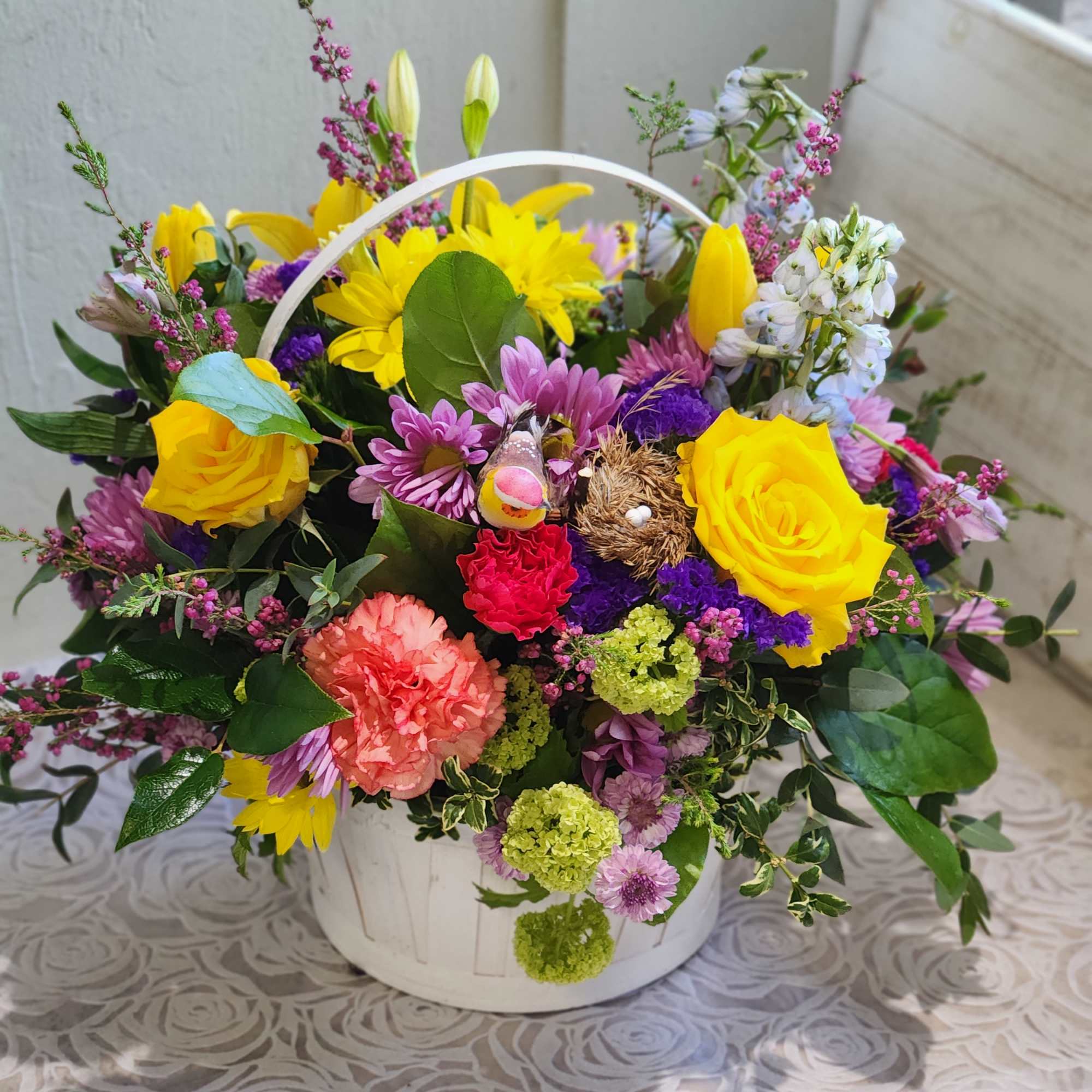 A cute spring basket with bright colors accented with curly willow and