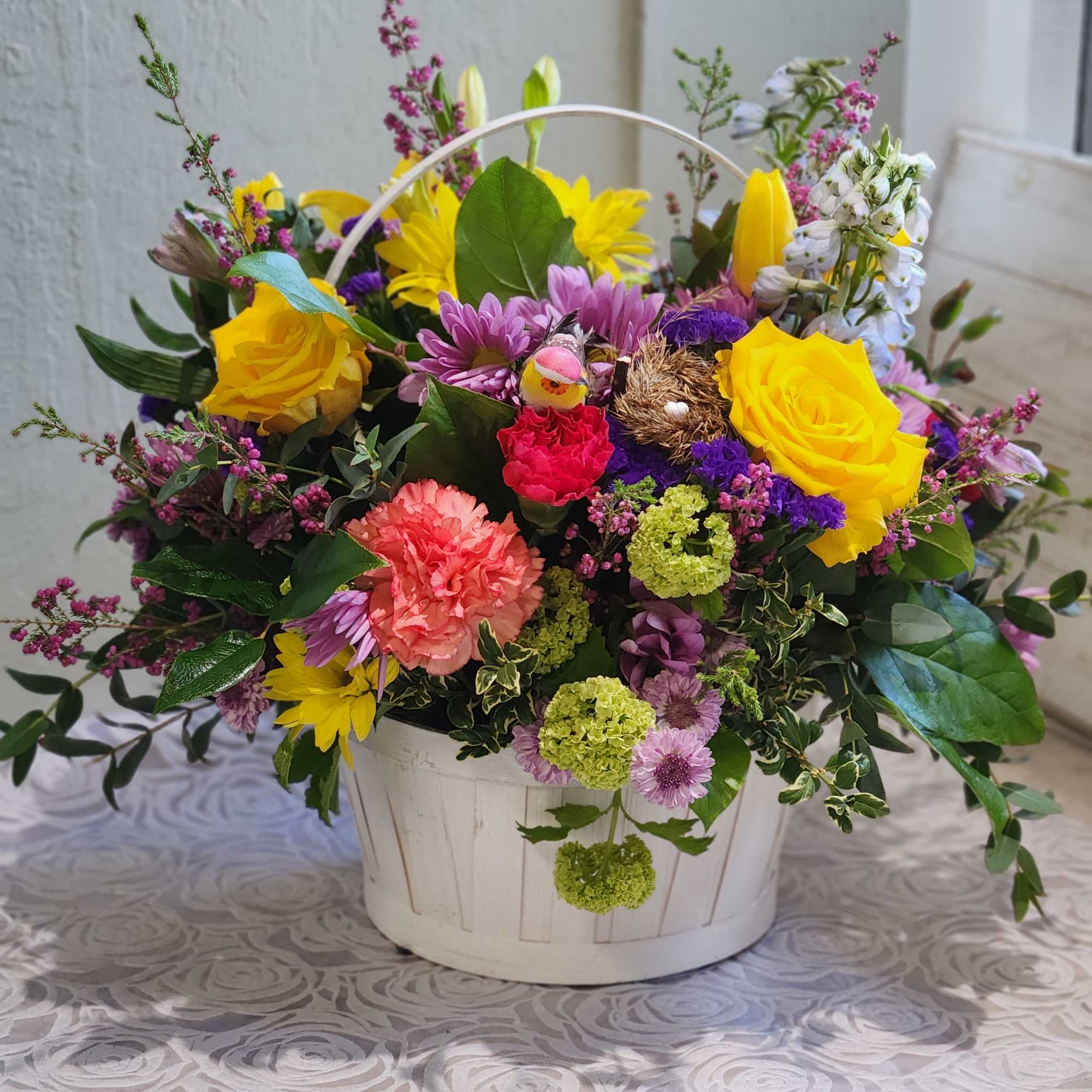 A cute spring basket with bright colors accented with curly willow and