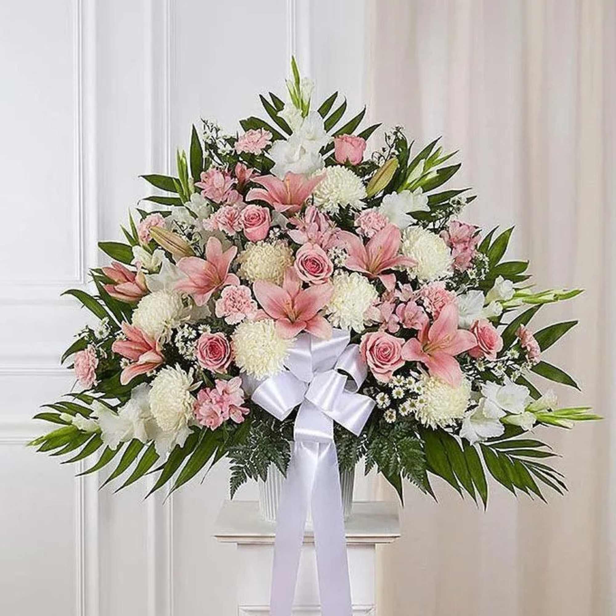 This standing basket is created with pink and white flowers including roses