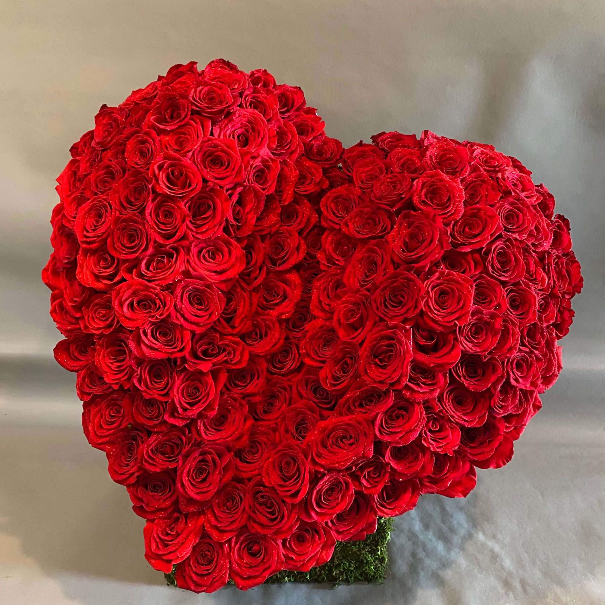 A giant red heart made entirely of stunning red roses atop a