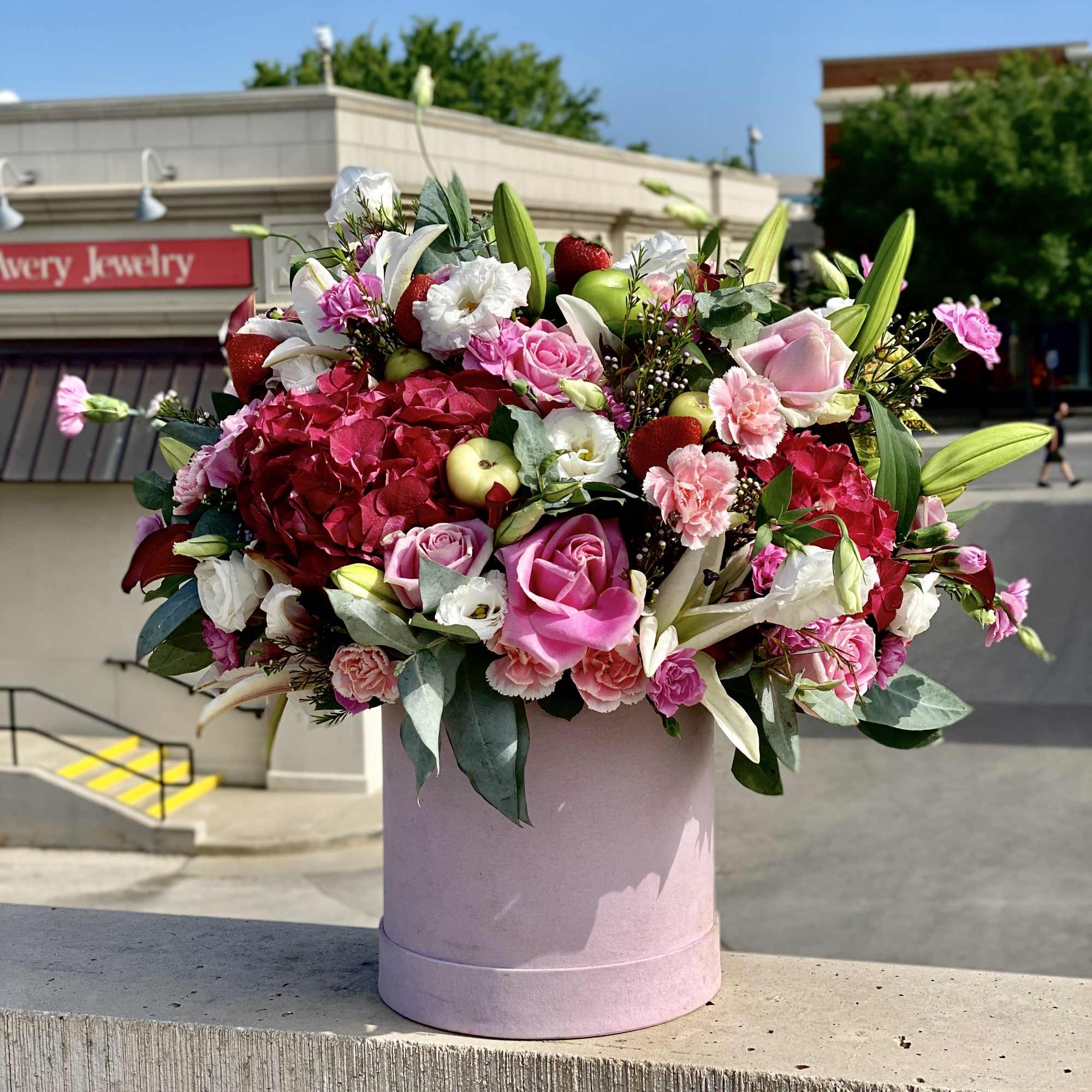 Pink, red and white blooms designed in a large oval flower box. Pink, red and white blooms designed in a large oval flower box.
