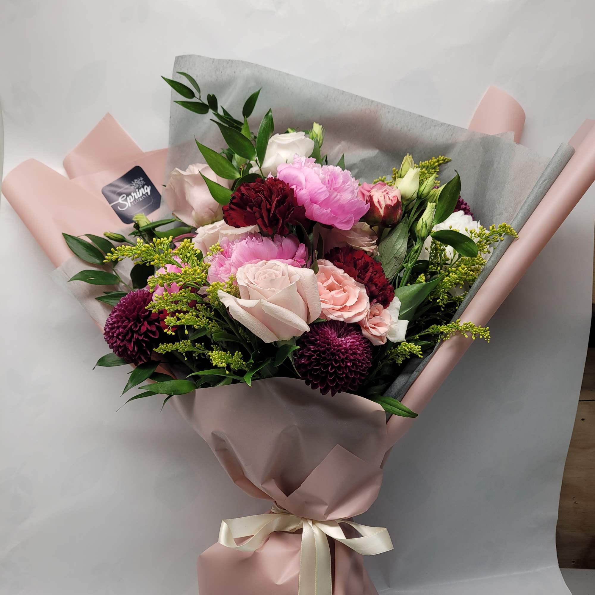 a collection of seasonally available blooms wrapped in our specialty wrapping and