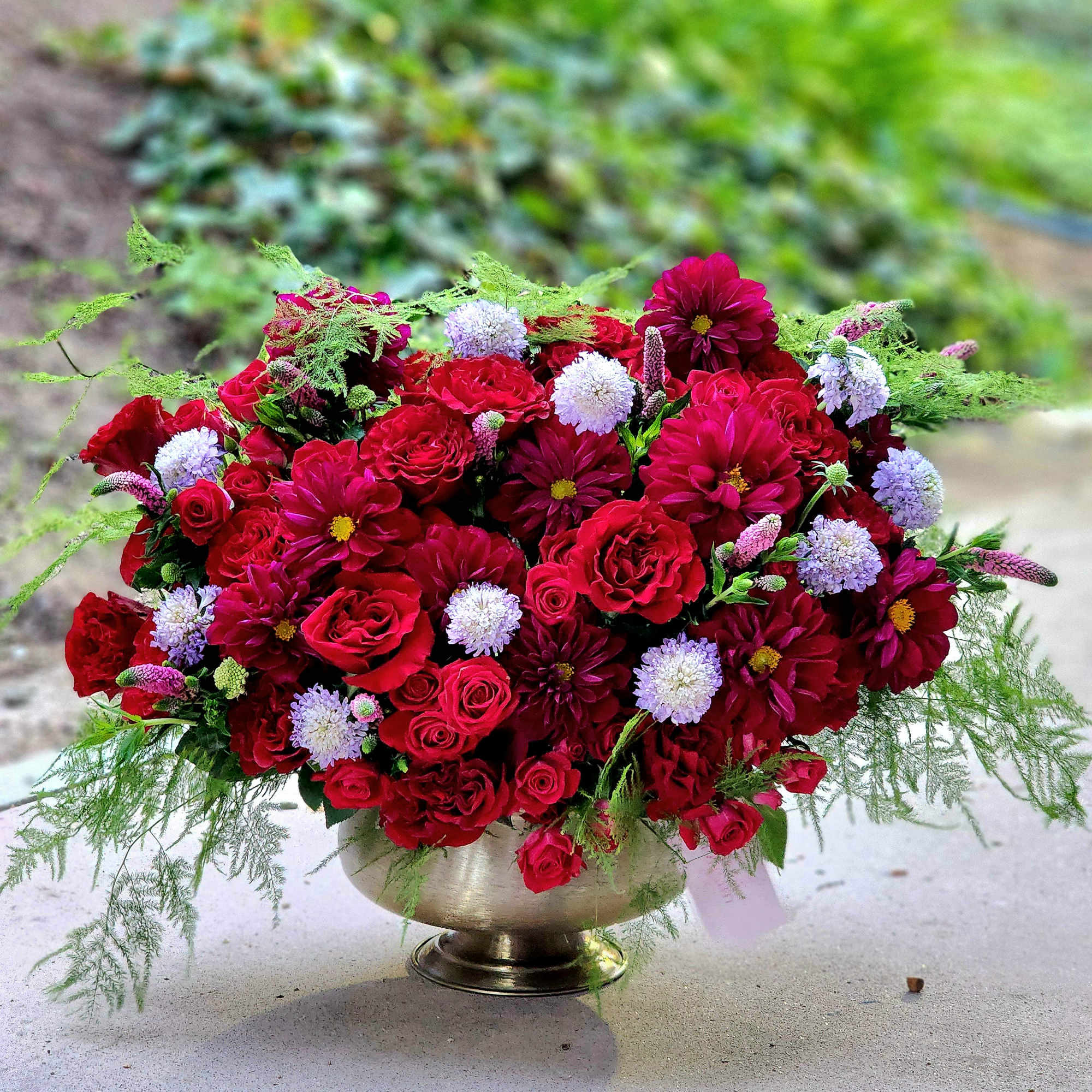 This luxurious arrangement features a stunning combination of deep red roses and