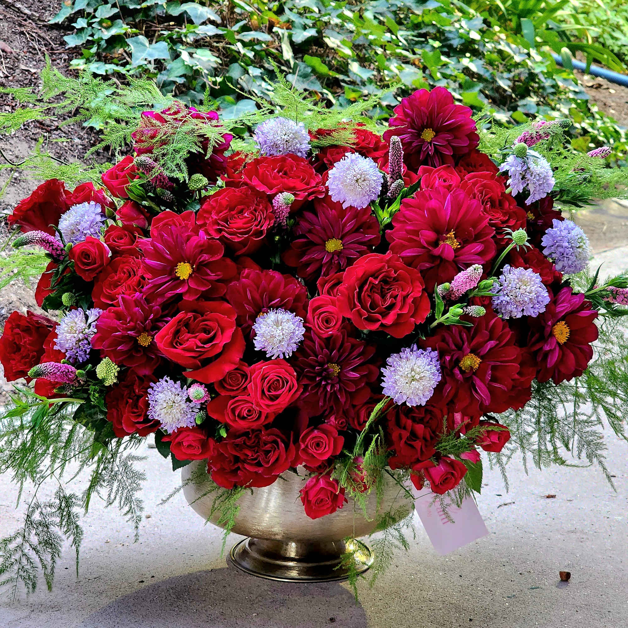 This luxurious arrangement features a stunning combination of deep red roses and