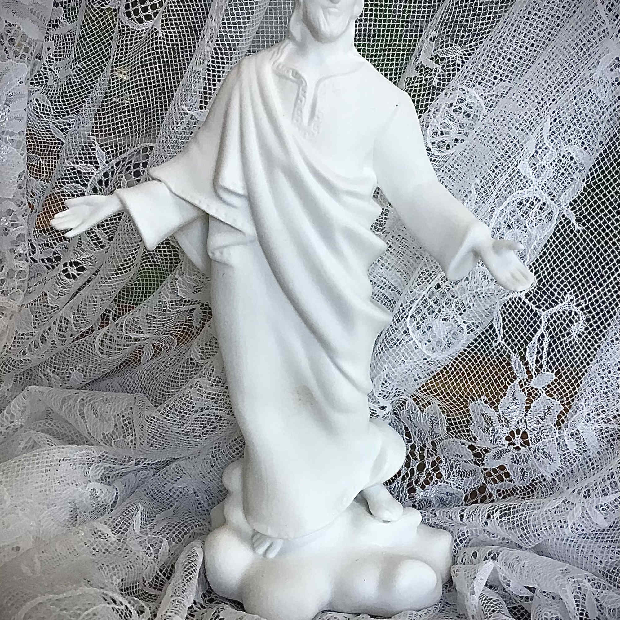 This exquisite porcelain sculpture of Jesus surrounded by radiant white flowers will