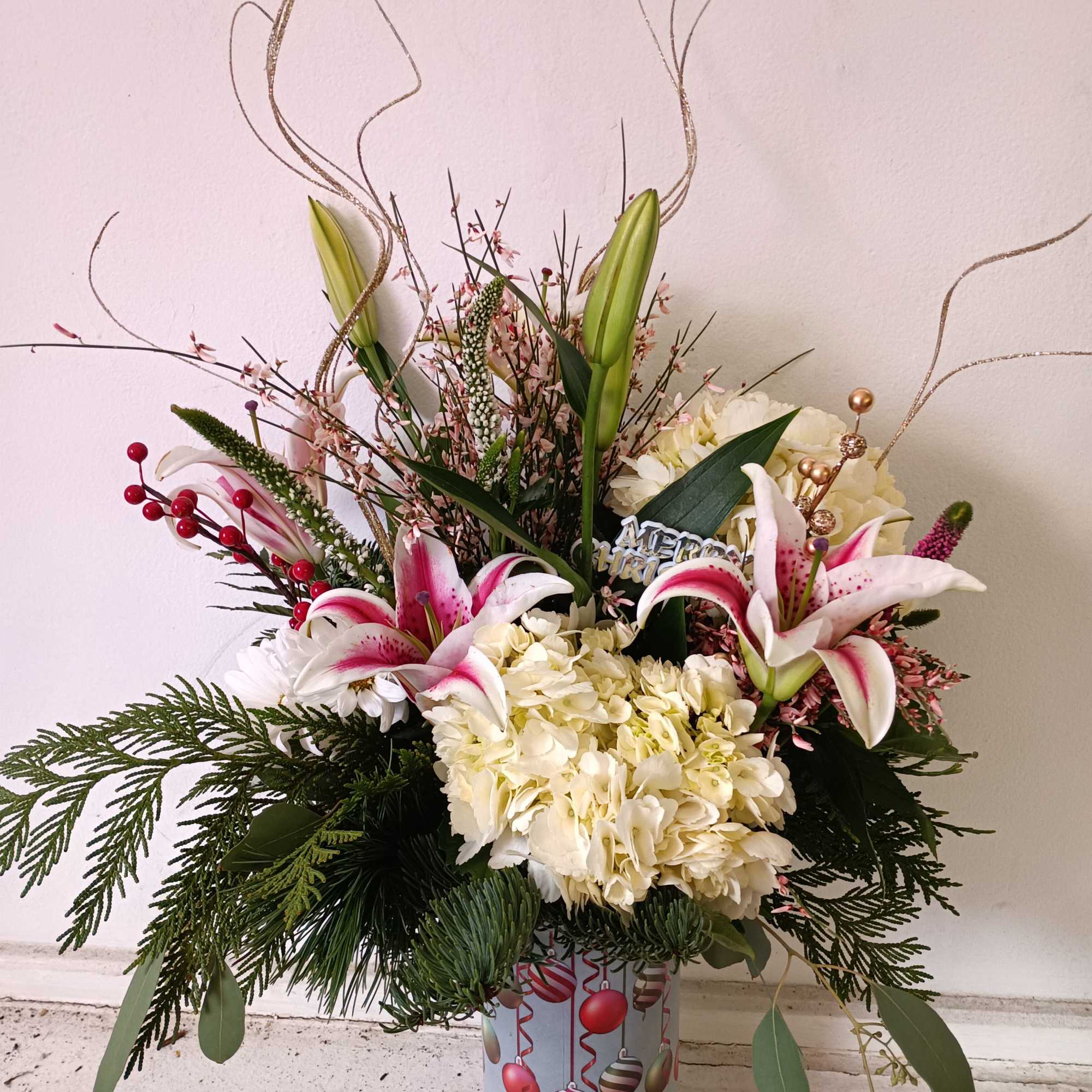 Festive Christas ornaments vase with varied Christmas greens, stargazer Lily, white hydrangea