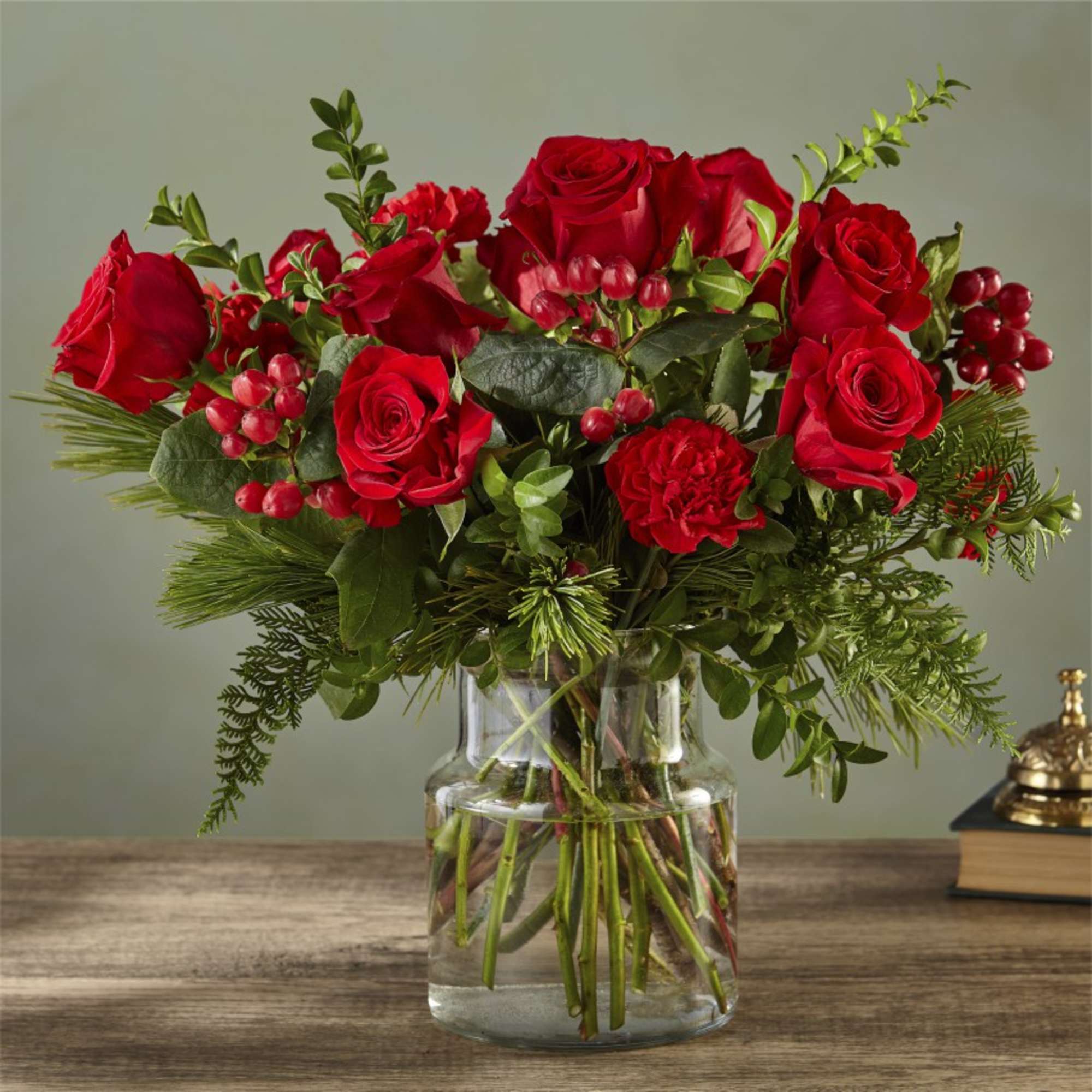 Seductive and serious, this deep crimson bouquet of roses, carnations, boxwood and
