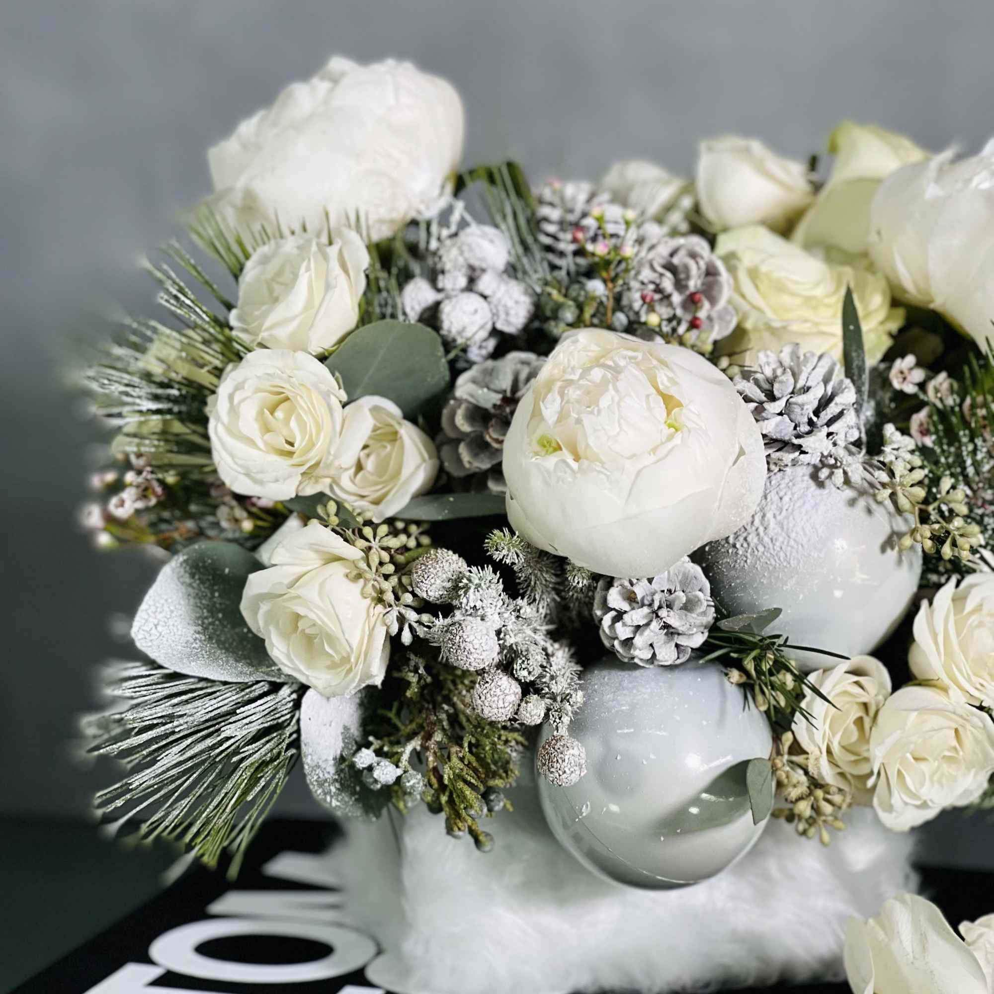 This arrangement will bring a sophisticated look with Peonies, Princess Holiday Greens