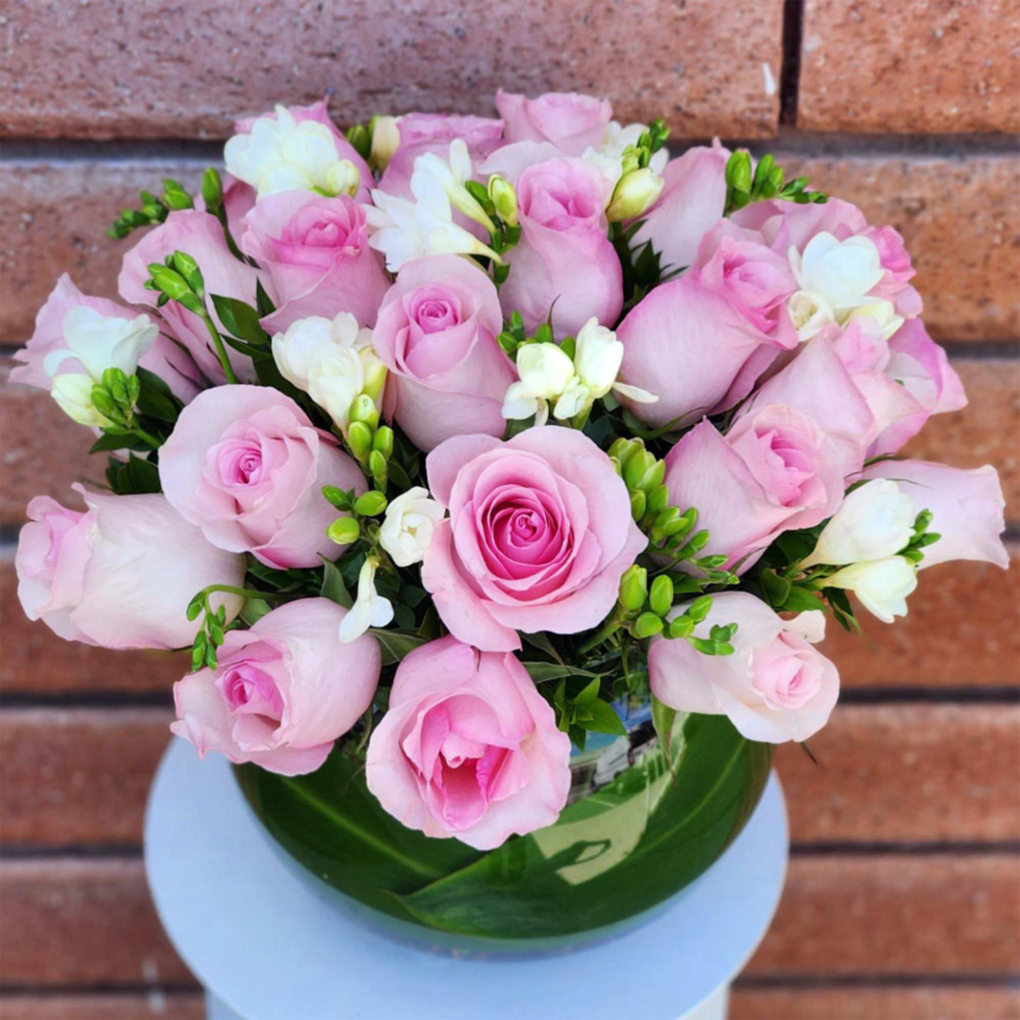 Unique soft pink roses and white freesias combine to create a mood
