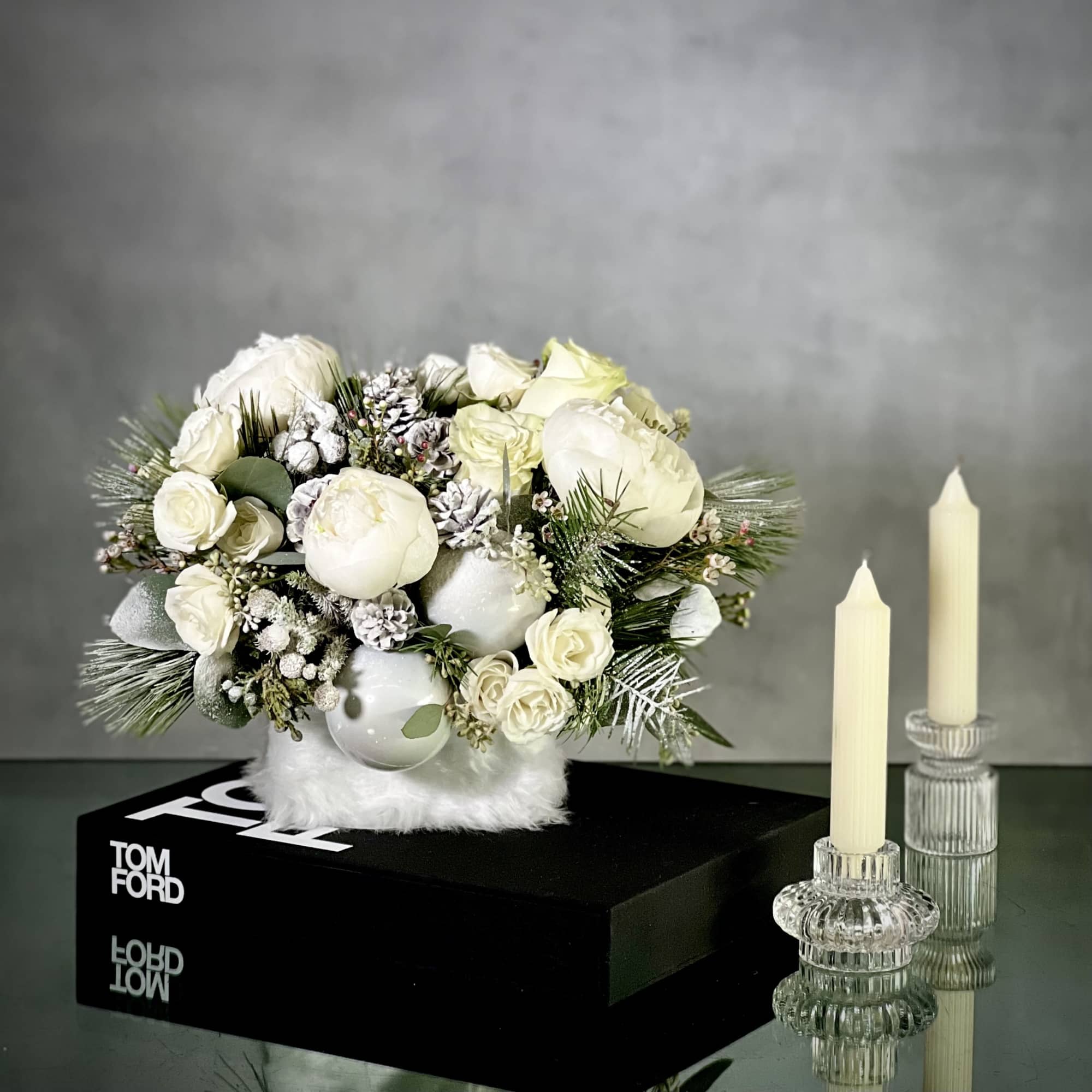 This arrangement will bring a sophisticated look with Peonies, Princess Holiday Greens