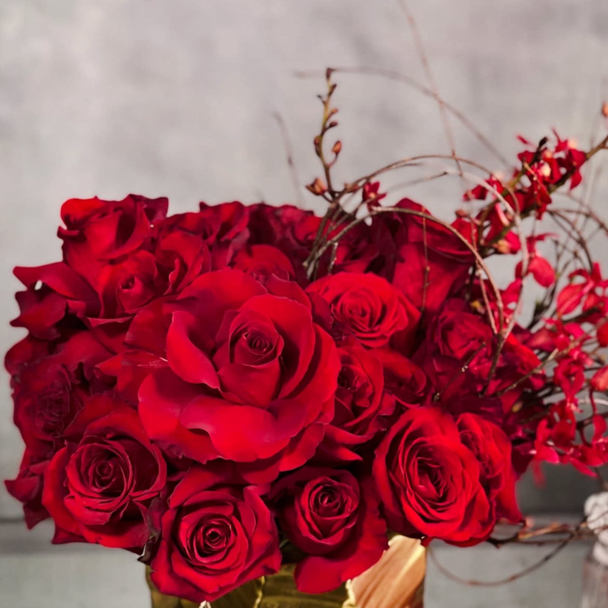 A lovely Gold Geometric vase holds this luscious arrangement of about 50