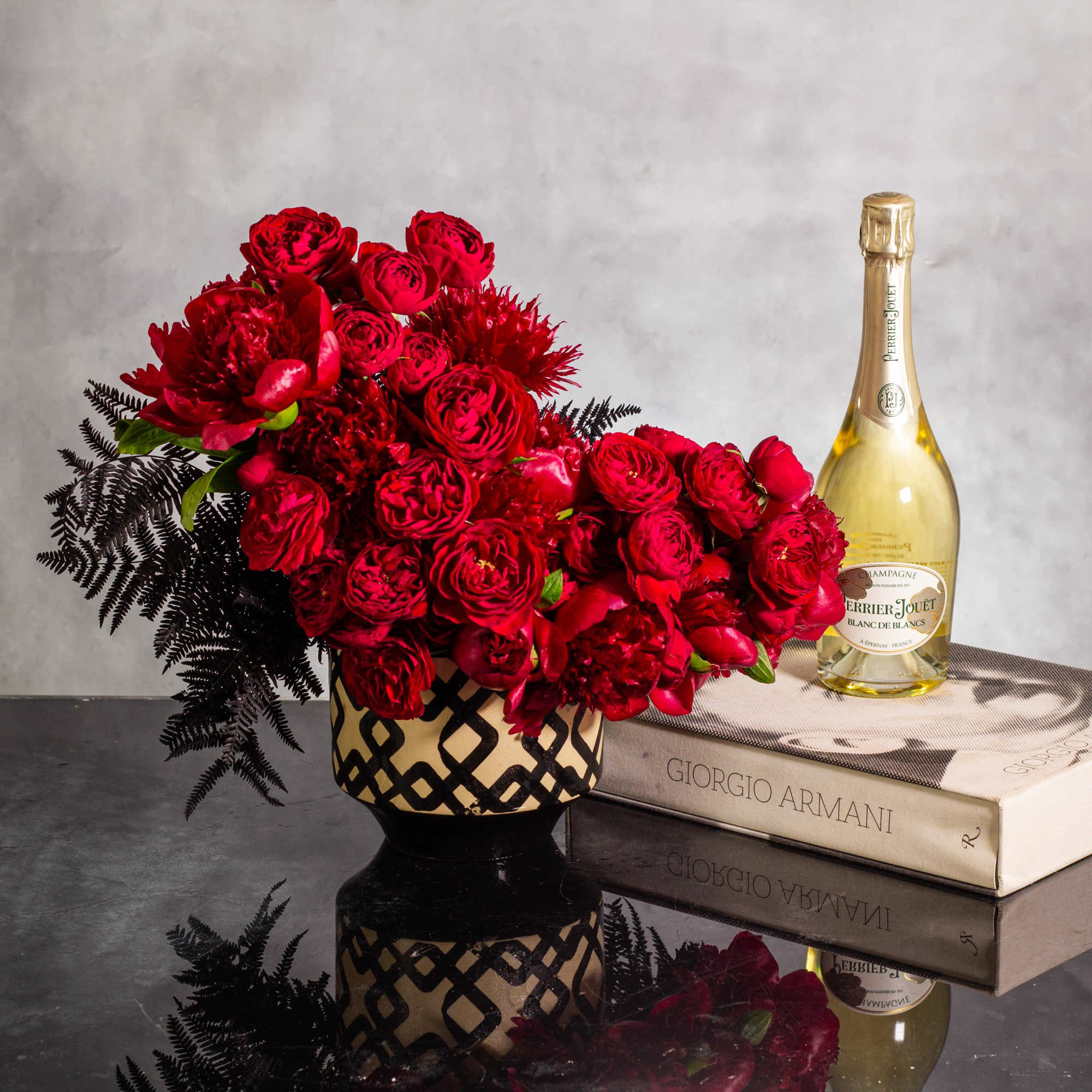 Imagine a striking floral arrangement featuring deep dark burgundy peonies and red