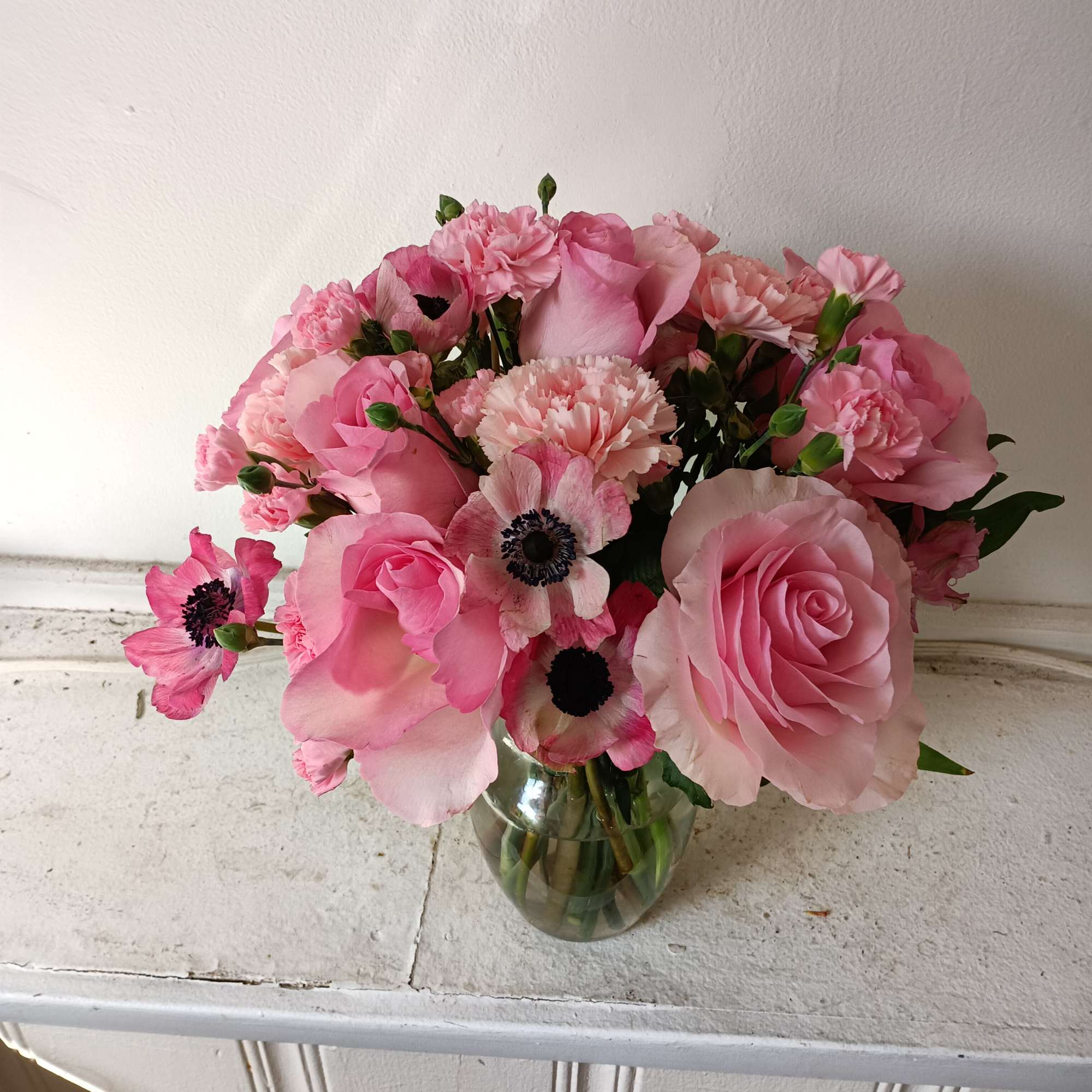 Beautiful light pink roses, pink carnations and anemones in a vase