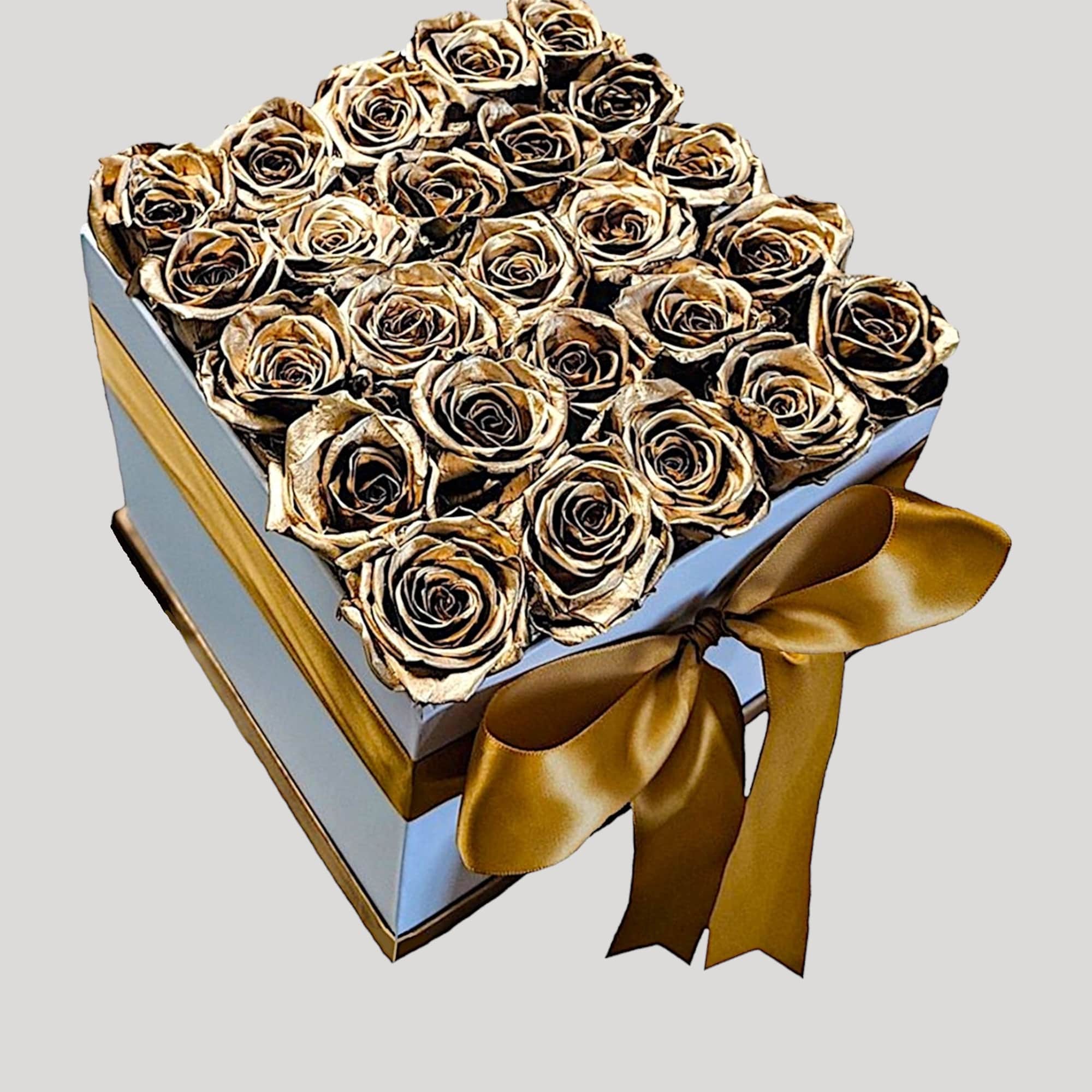 A modern flower arrangement in a white box filled with gold painted