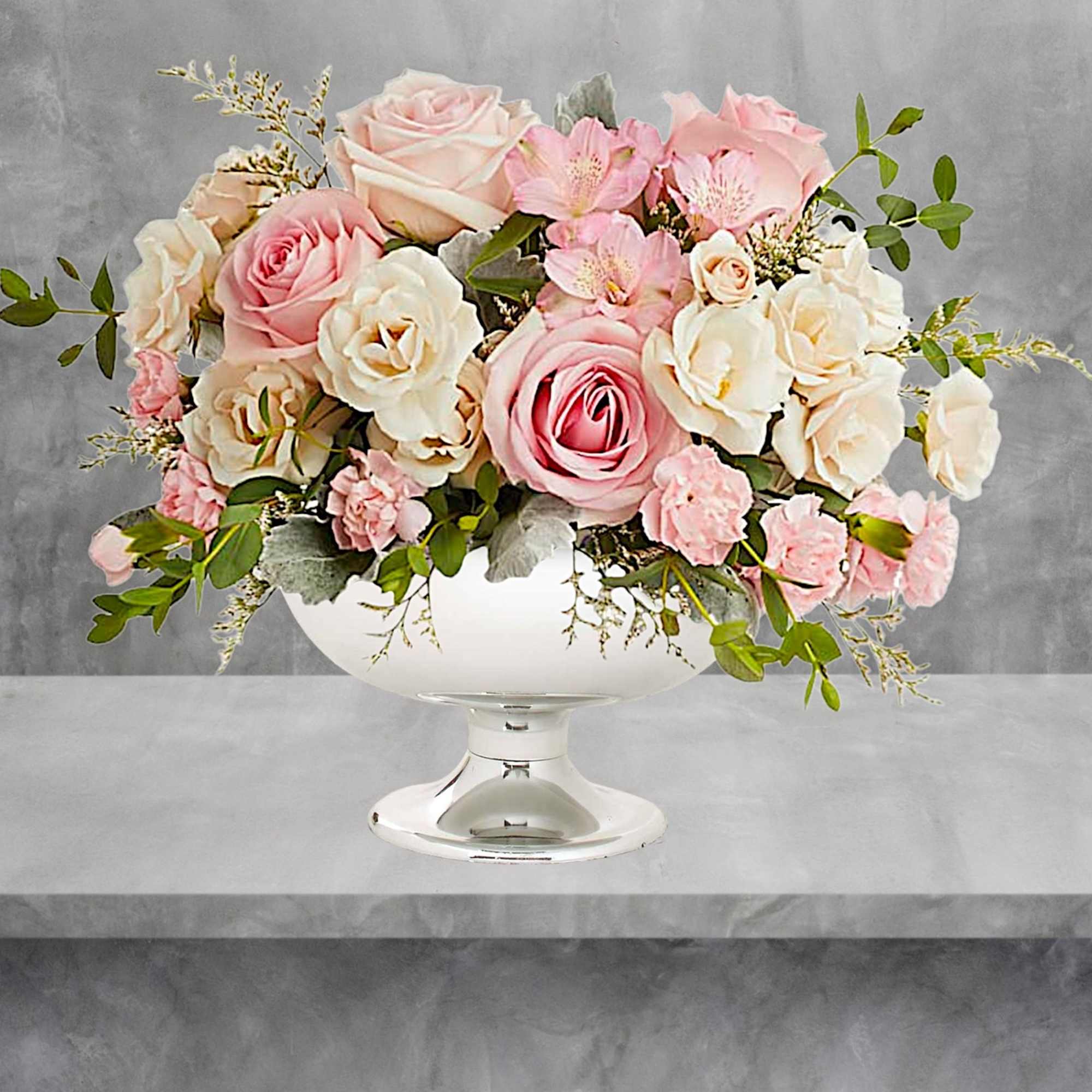 Illuminate love with embracing soft pastel shimmer and cradling an exquisite arrangement